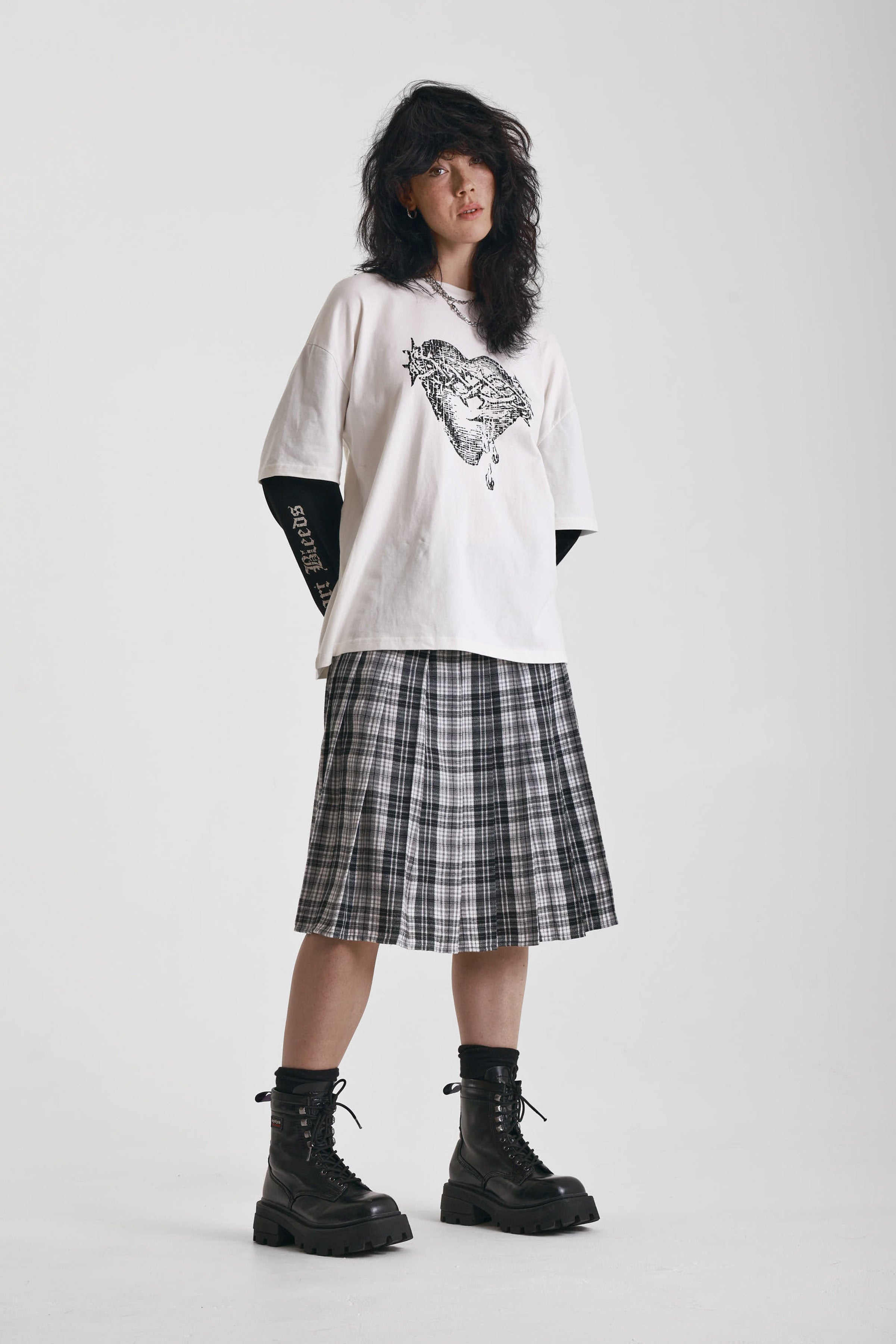 Black and white mixed check midi skirt with silver piercing hardware, worn by model