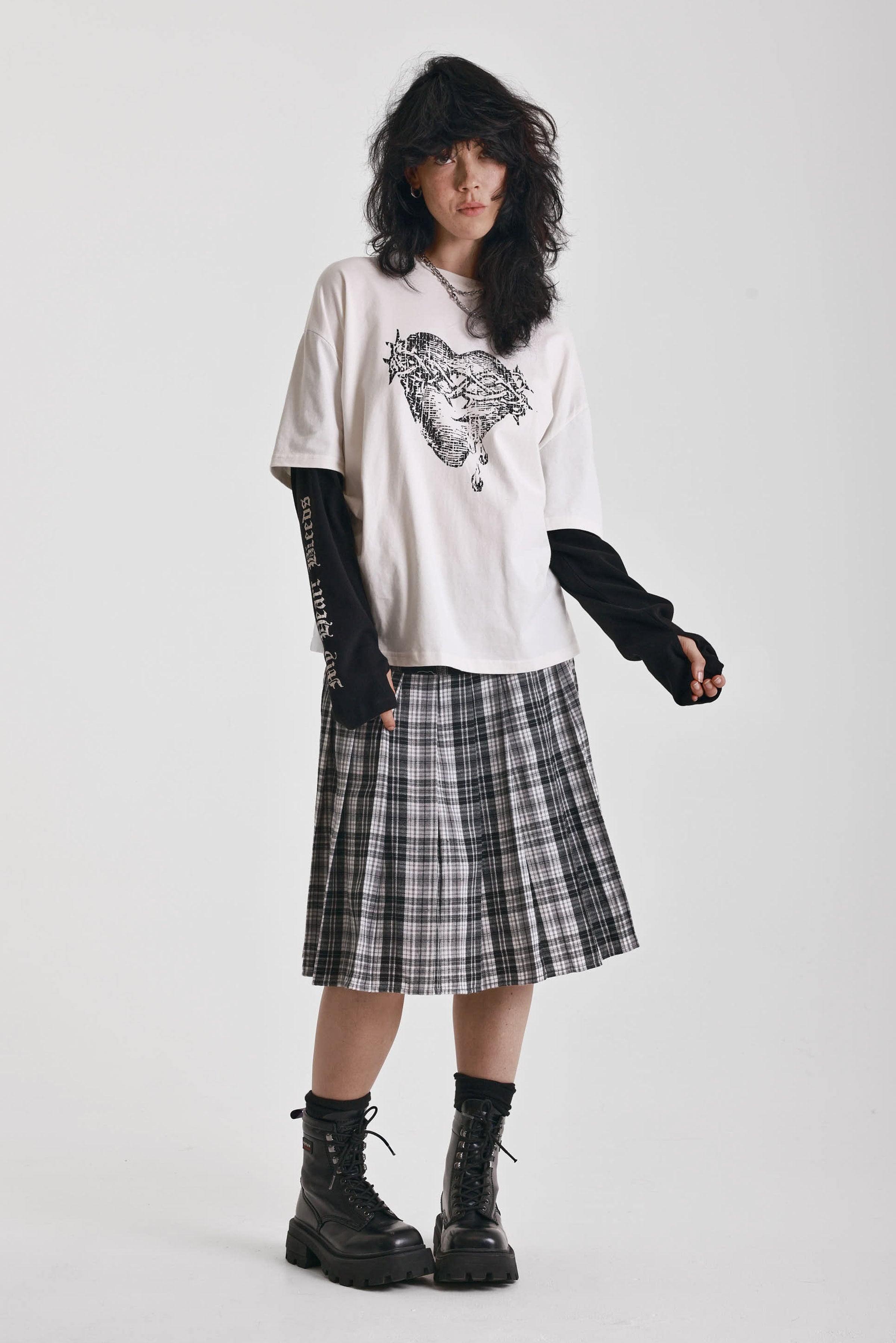 Black and white mixed check midi skirt with silver piercing hardware, worn by model