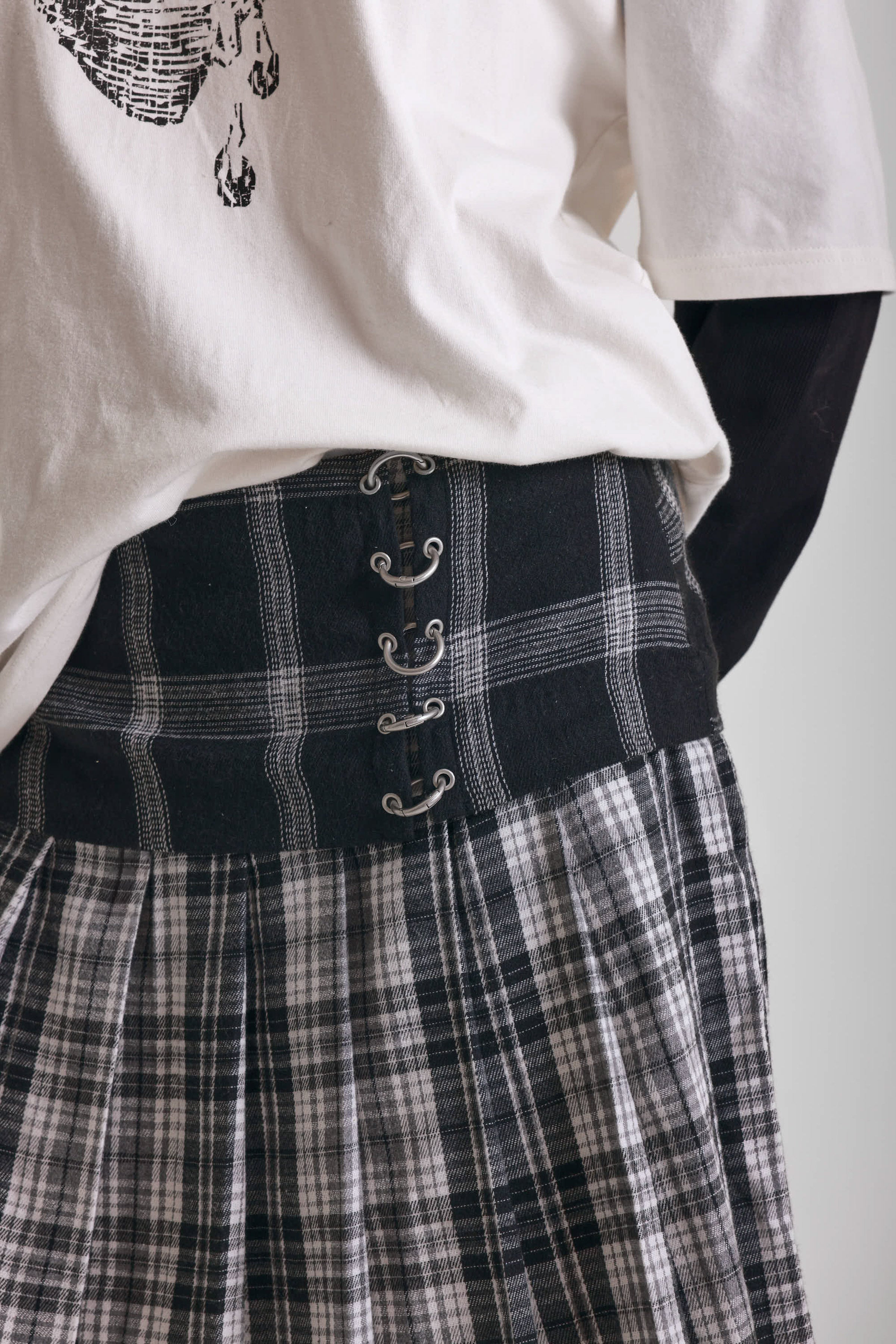 Black and white mixed check midi skirt with silver piercing hardware, worn by model