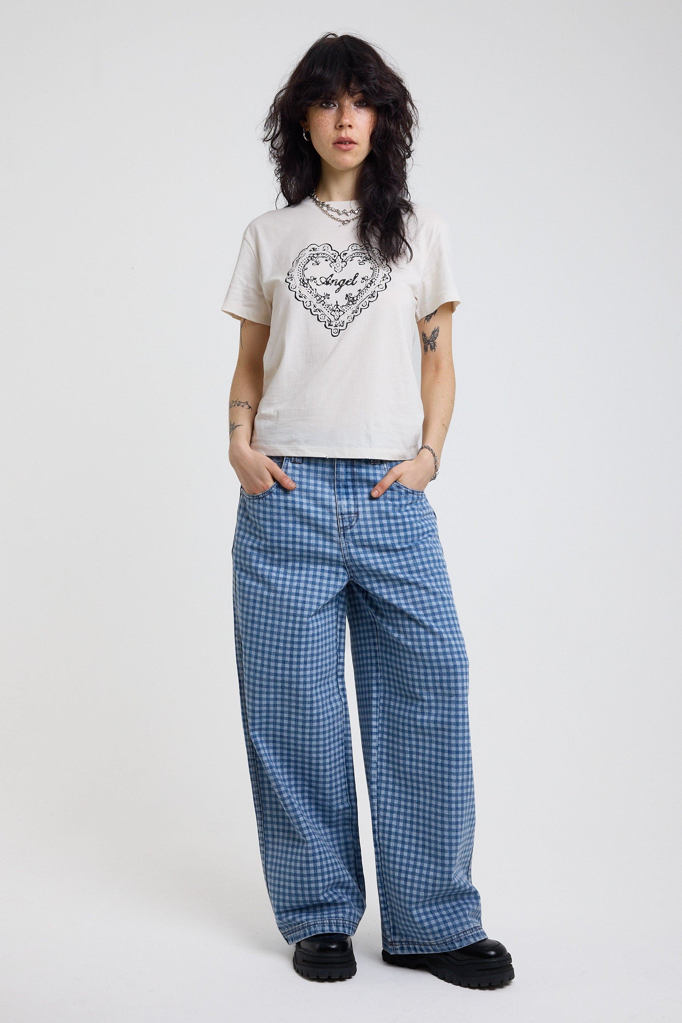 White shrunken baby t-shirt with vintage angel graphic print, worn by a model