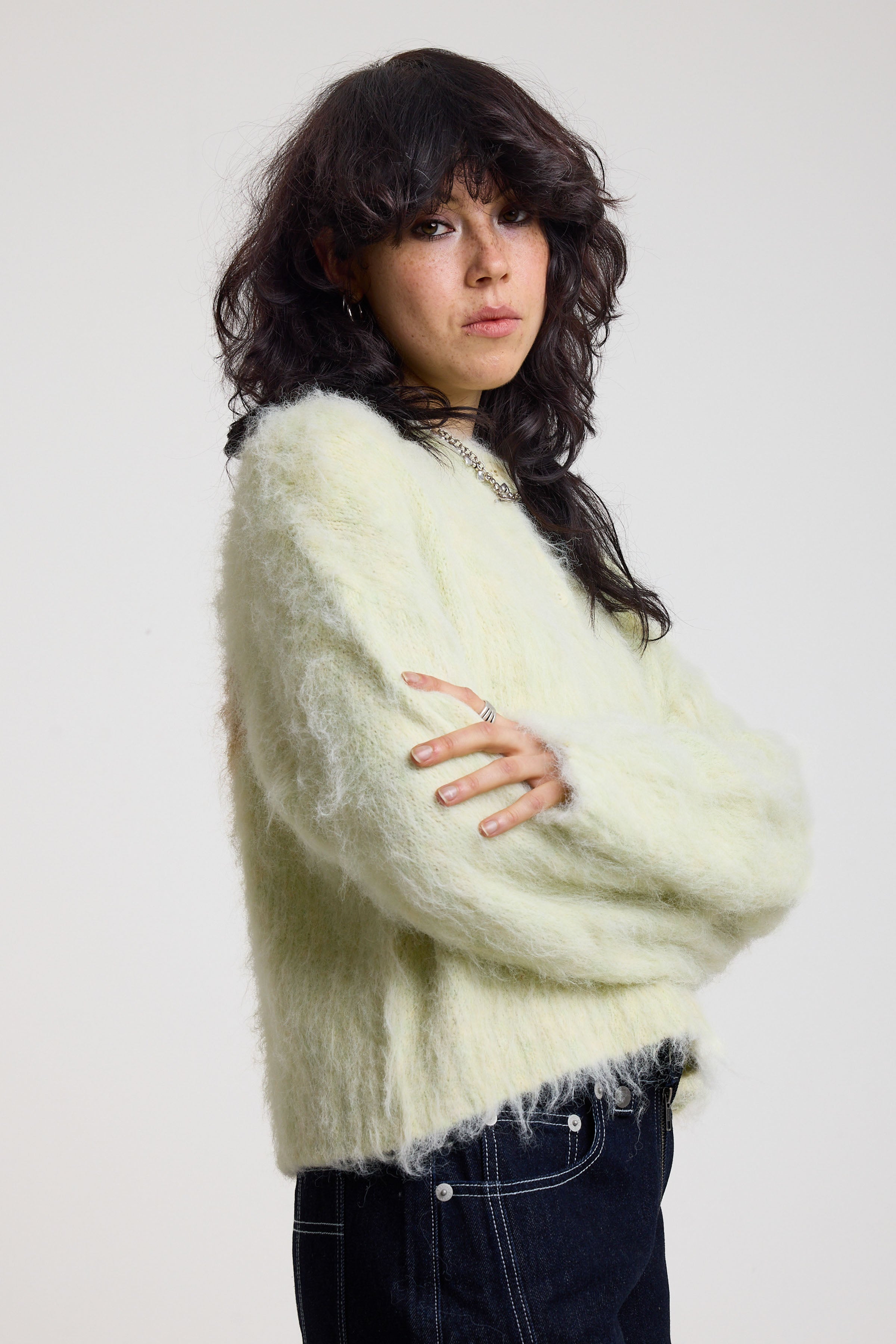 Pale green fuzzy knit cardigan with gothic Baby slogan on back, worn by model