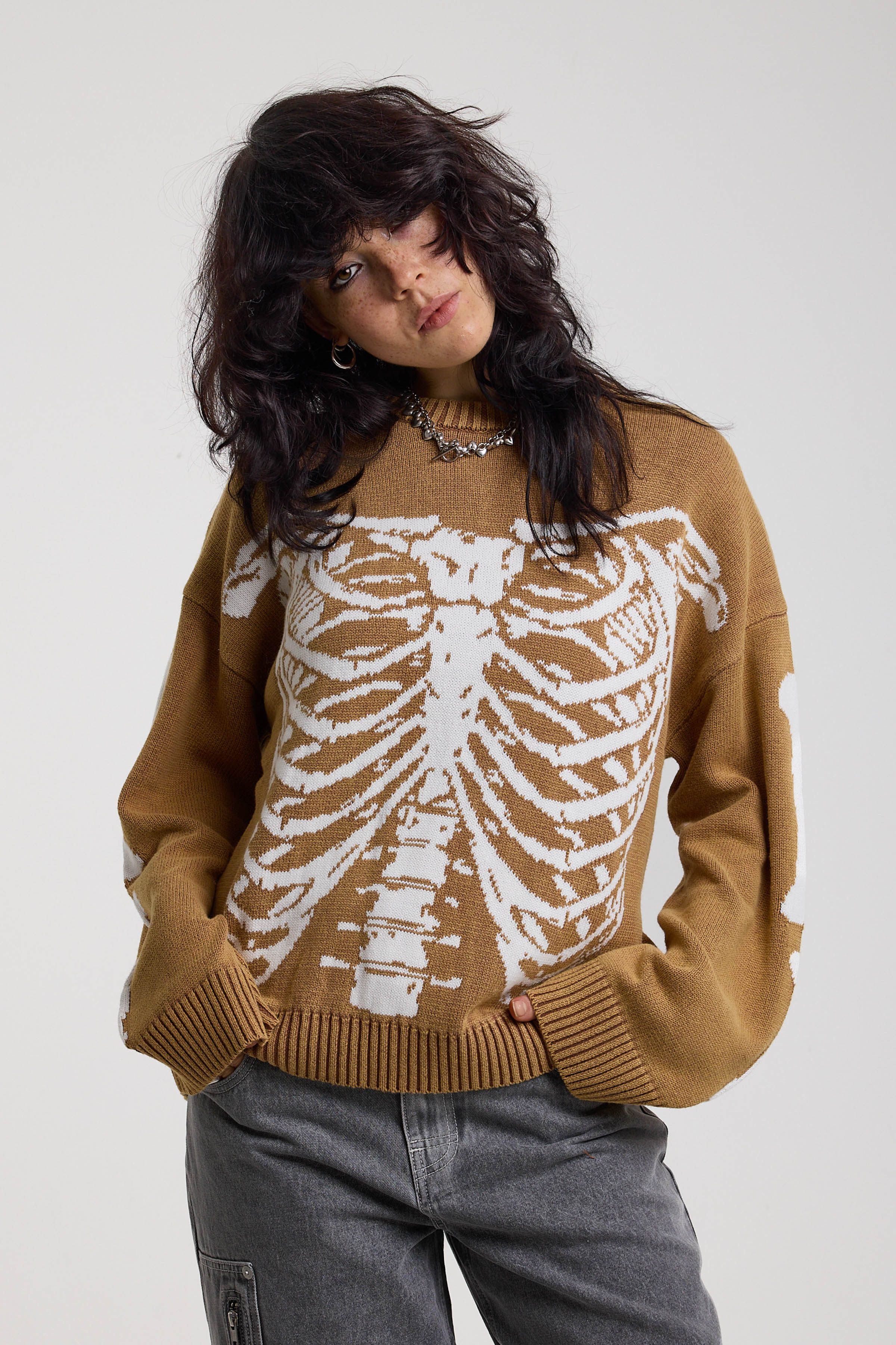 Brown oversized knit jumper with skeleton graphic, worn by model