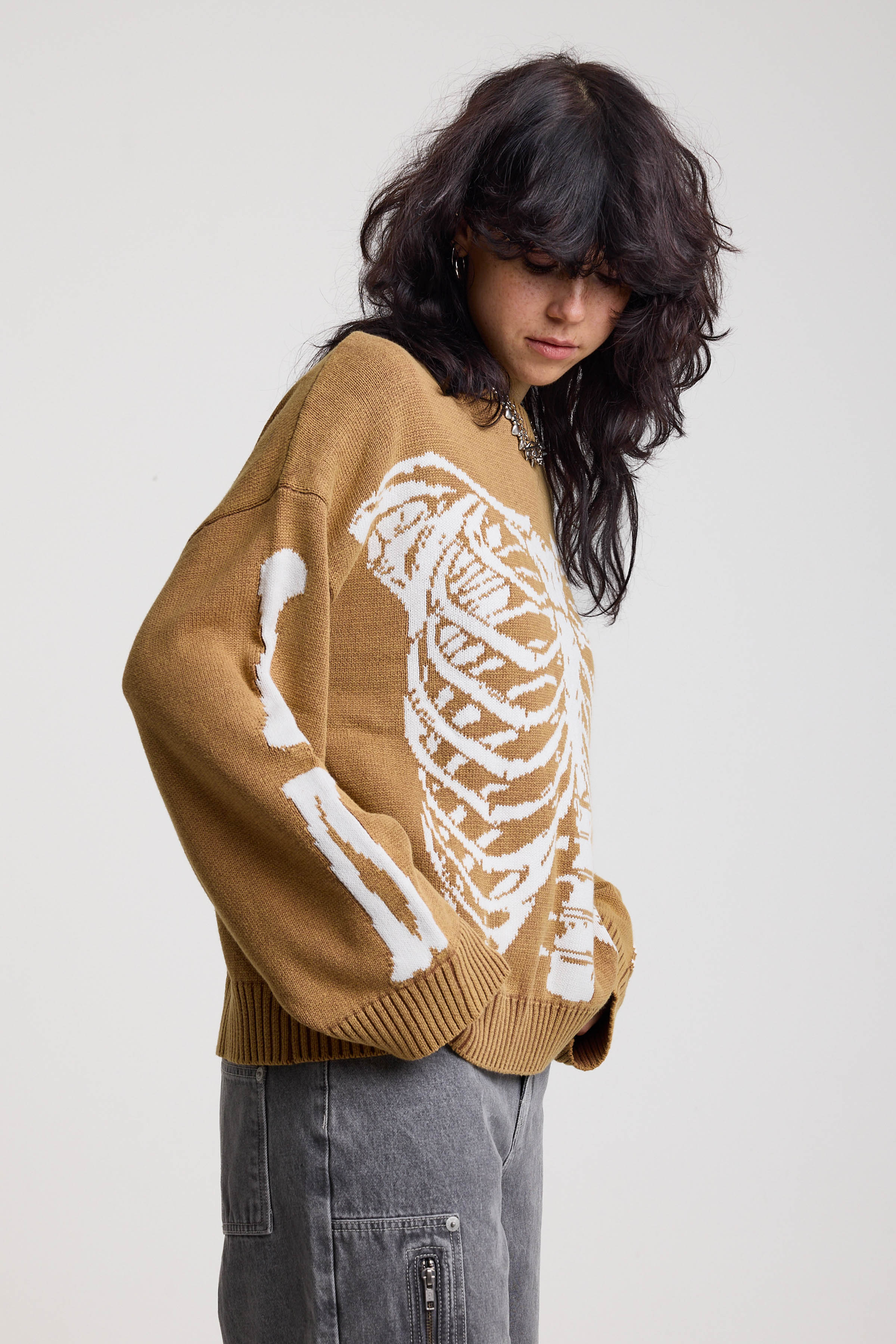 Brown oversized knit jumper with skeleton graphic, worn by model