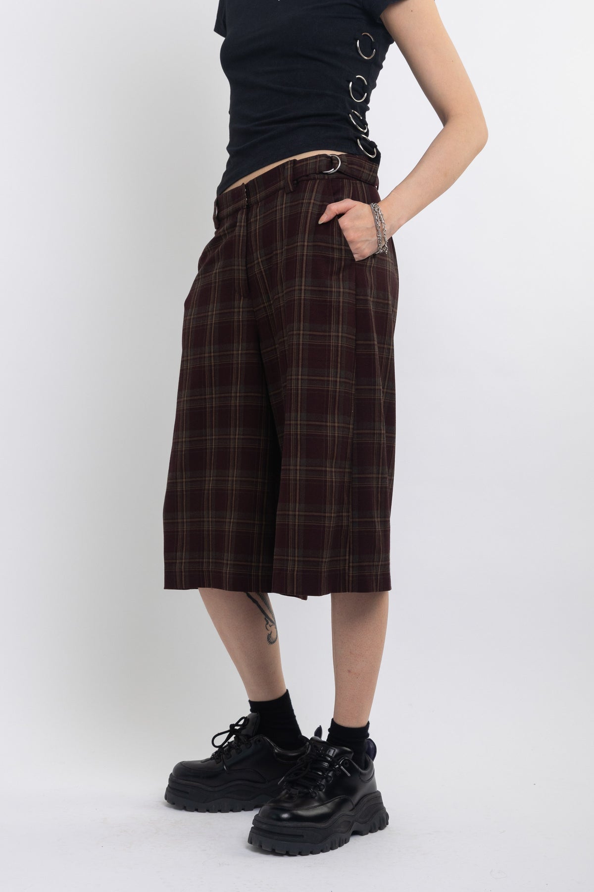 Burgundy check longline tailored shorts with silver D-ring hardware worn by model