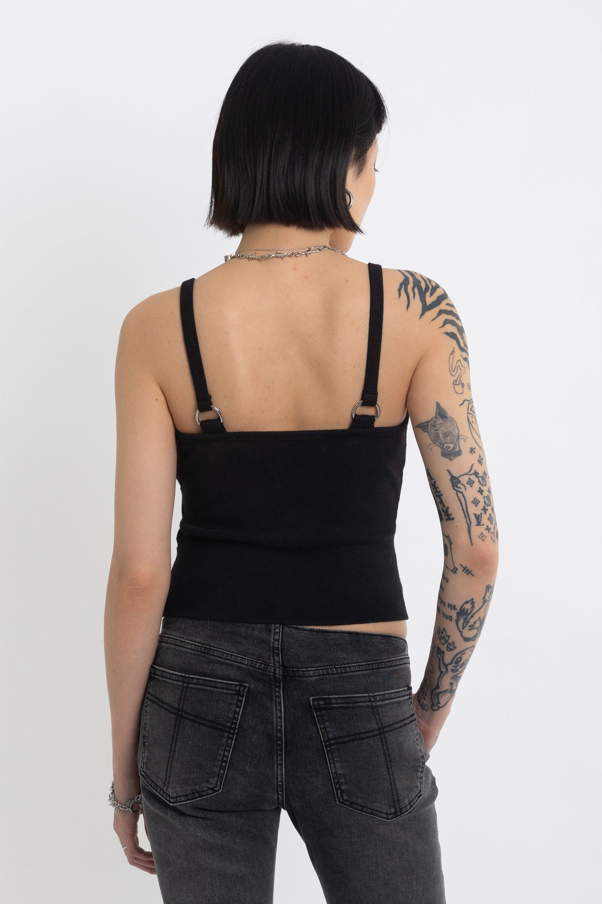 Black plunging wrap top with silver trigger clasps, worn by model