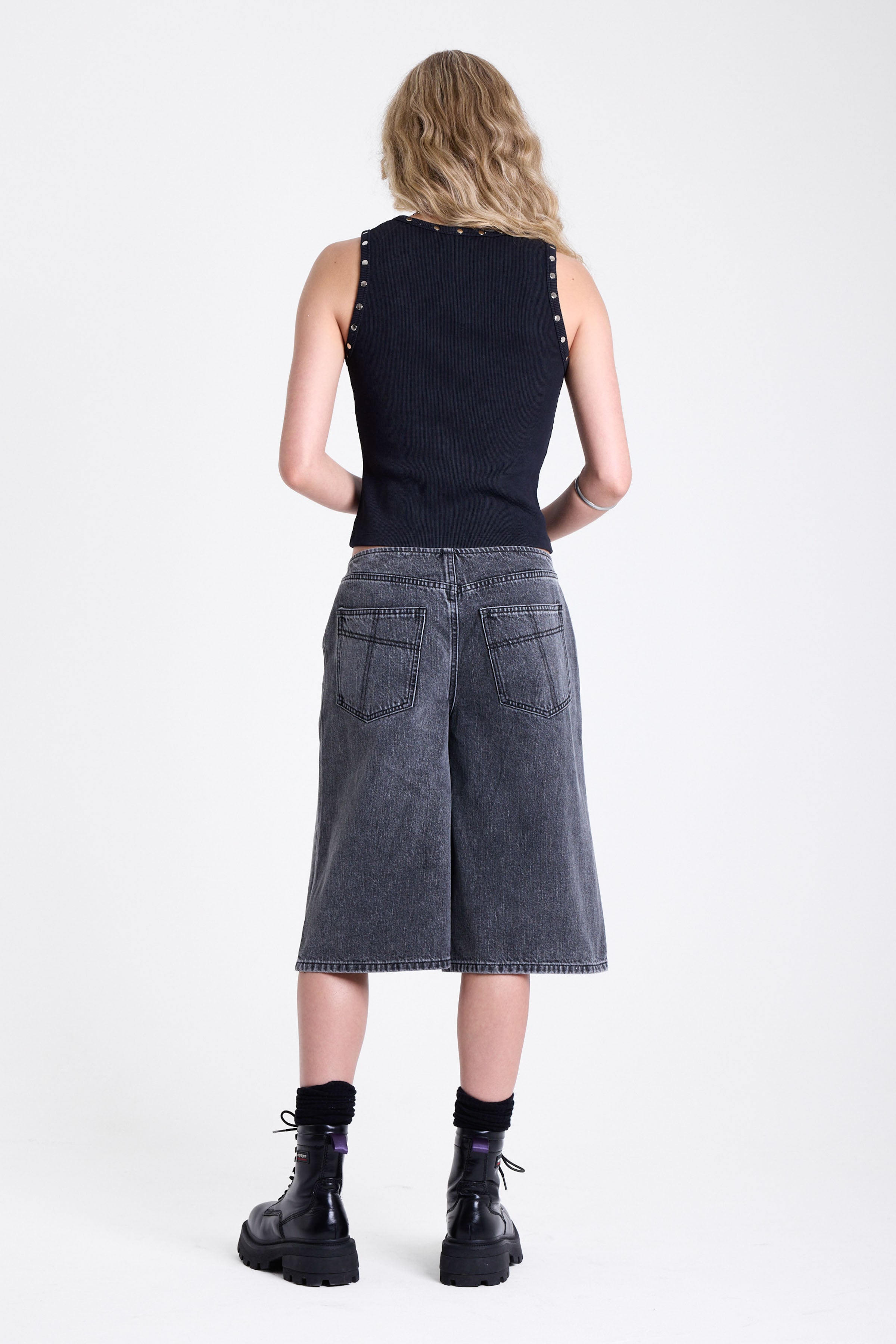 Washed black longline oversized denim jorts with no waistband and silver latch clasp detail, worn by model