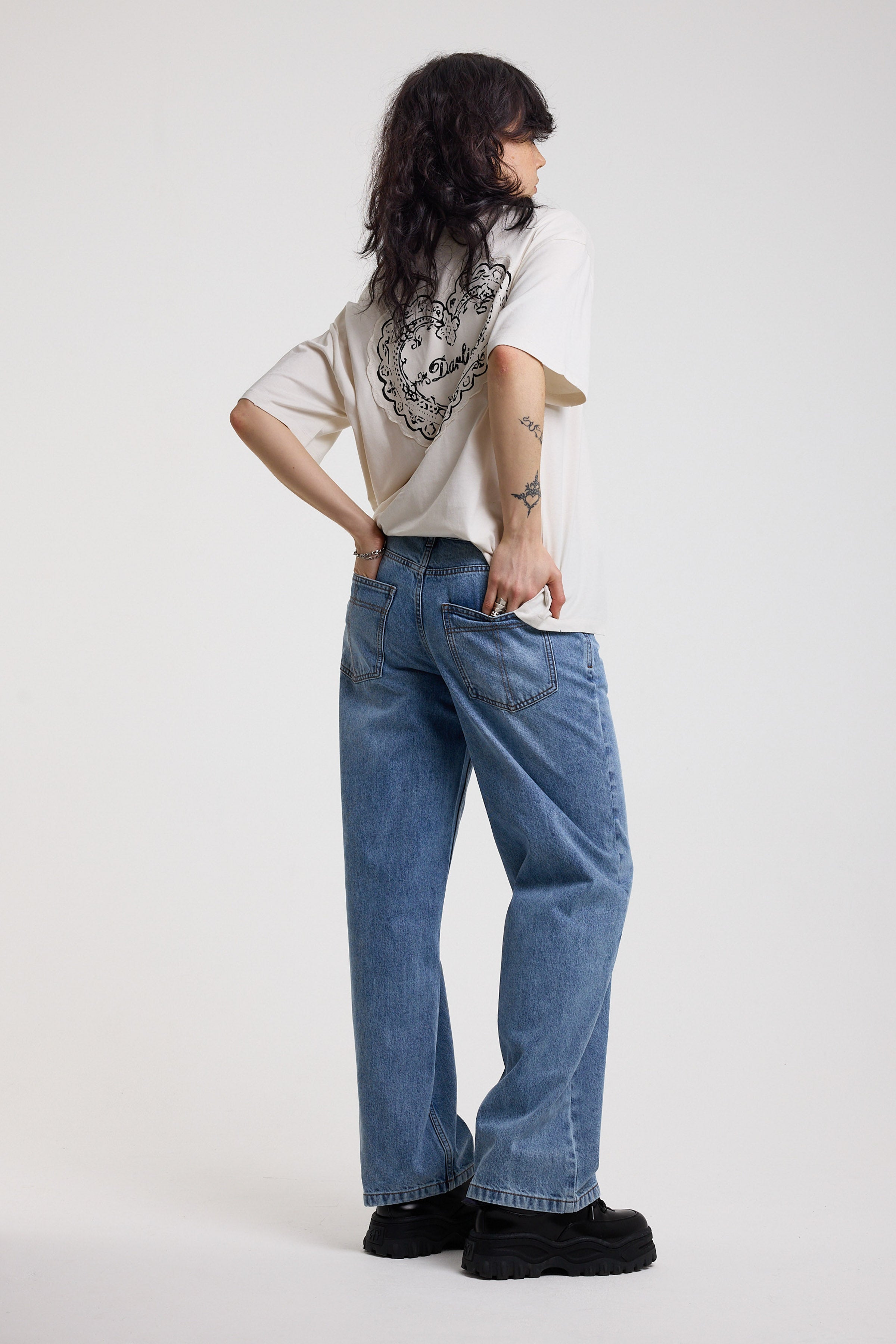 Back image of blue baggy balloon boyfriend jeans with denim tie belt, worn by model