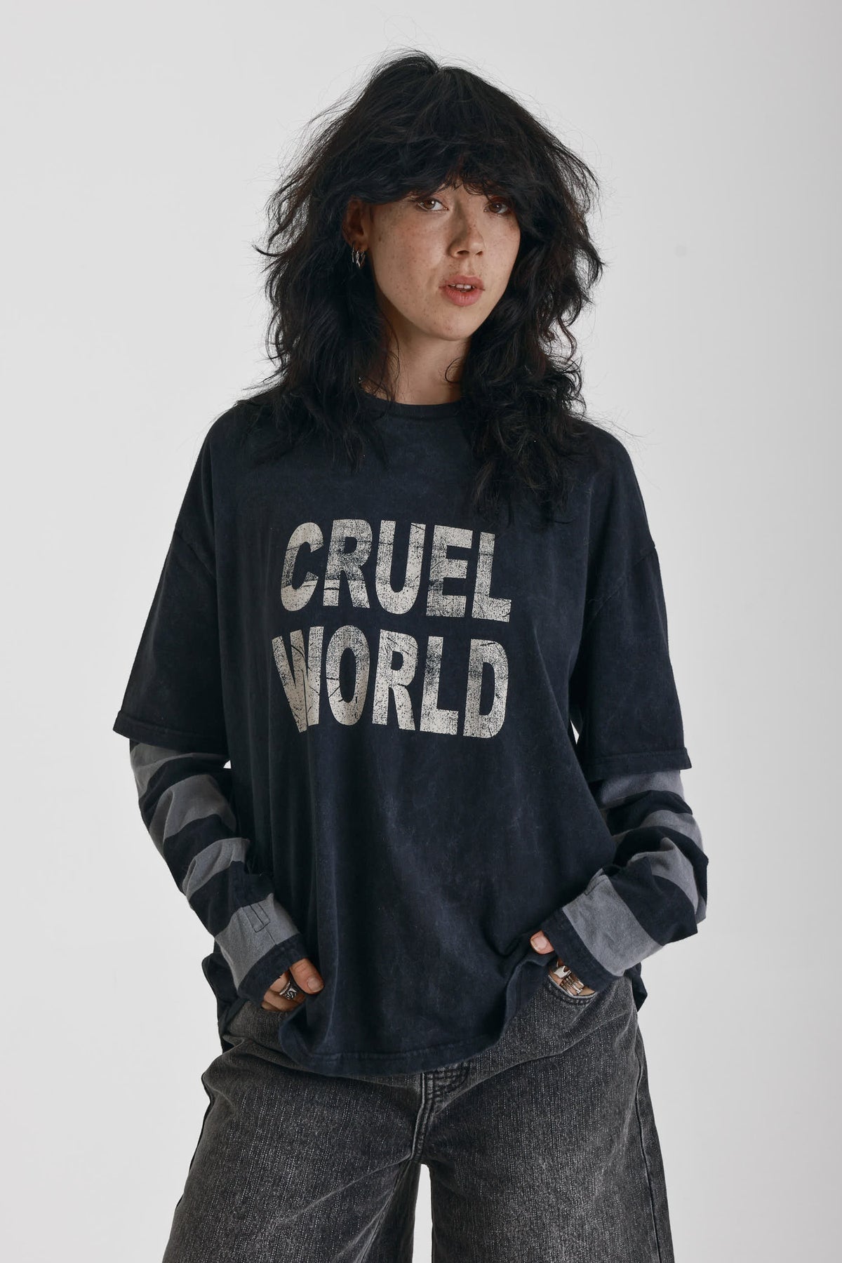 Washed black long sleeve skate t-shirt with CRUEL WORLD graphic print and contrast stripe sleeves, worn by model
