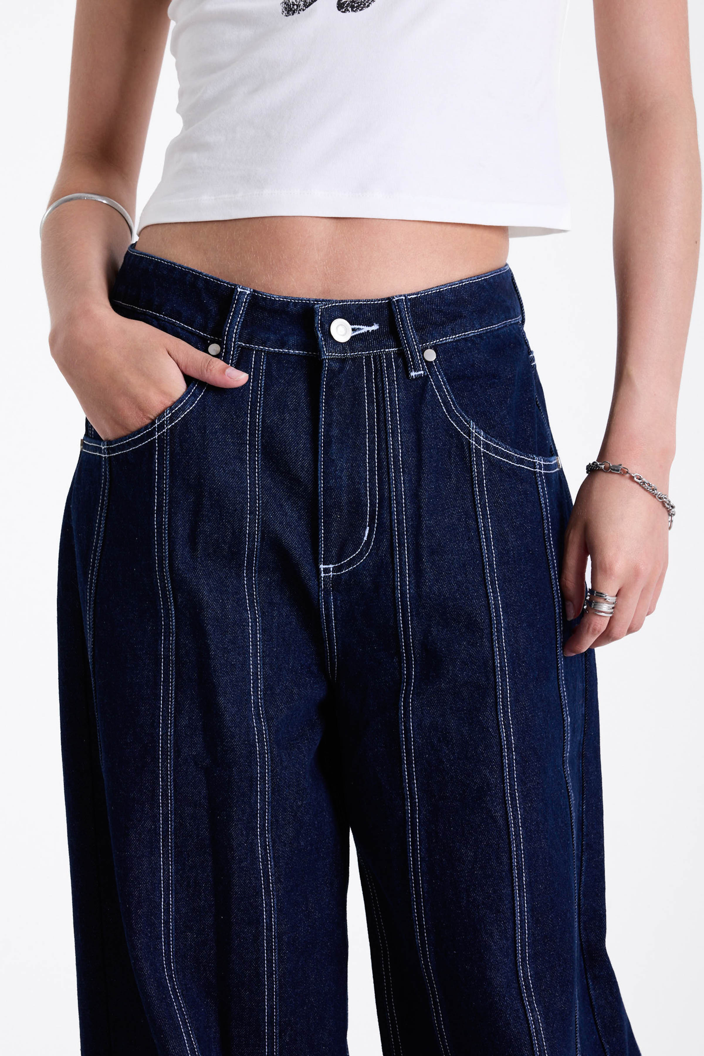 Dark rinse denim baggy wide leg jeans with contrast seam detail, worn by model.