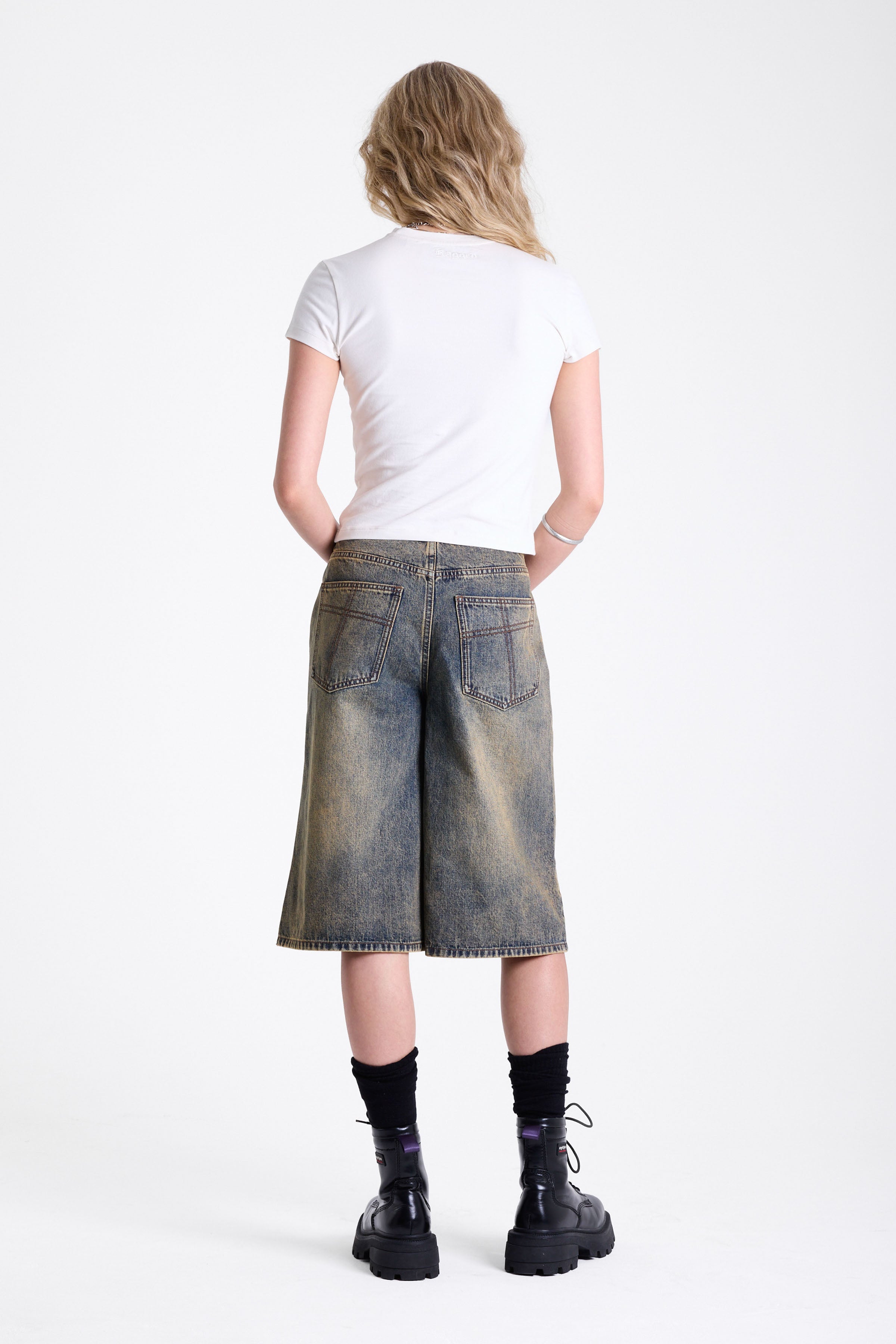 Dirty wash longline oversized denim jorts with no waistband and silver latch clasp detail, worn by model