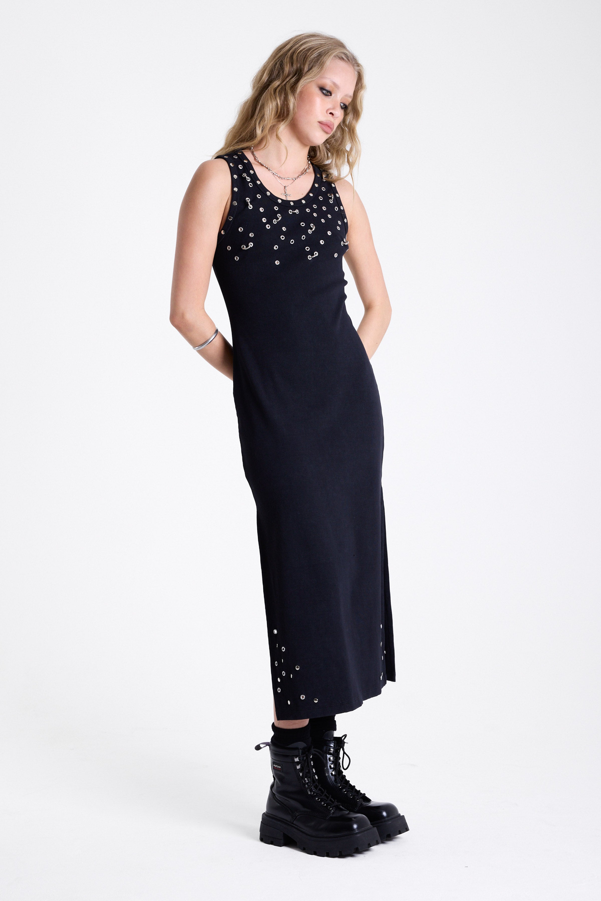 Black bodycon maxi dress with silver stud and piercing detail, worn by model