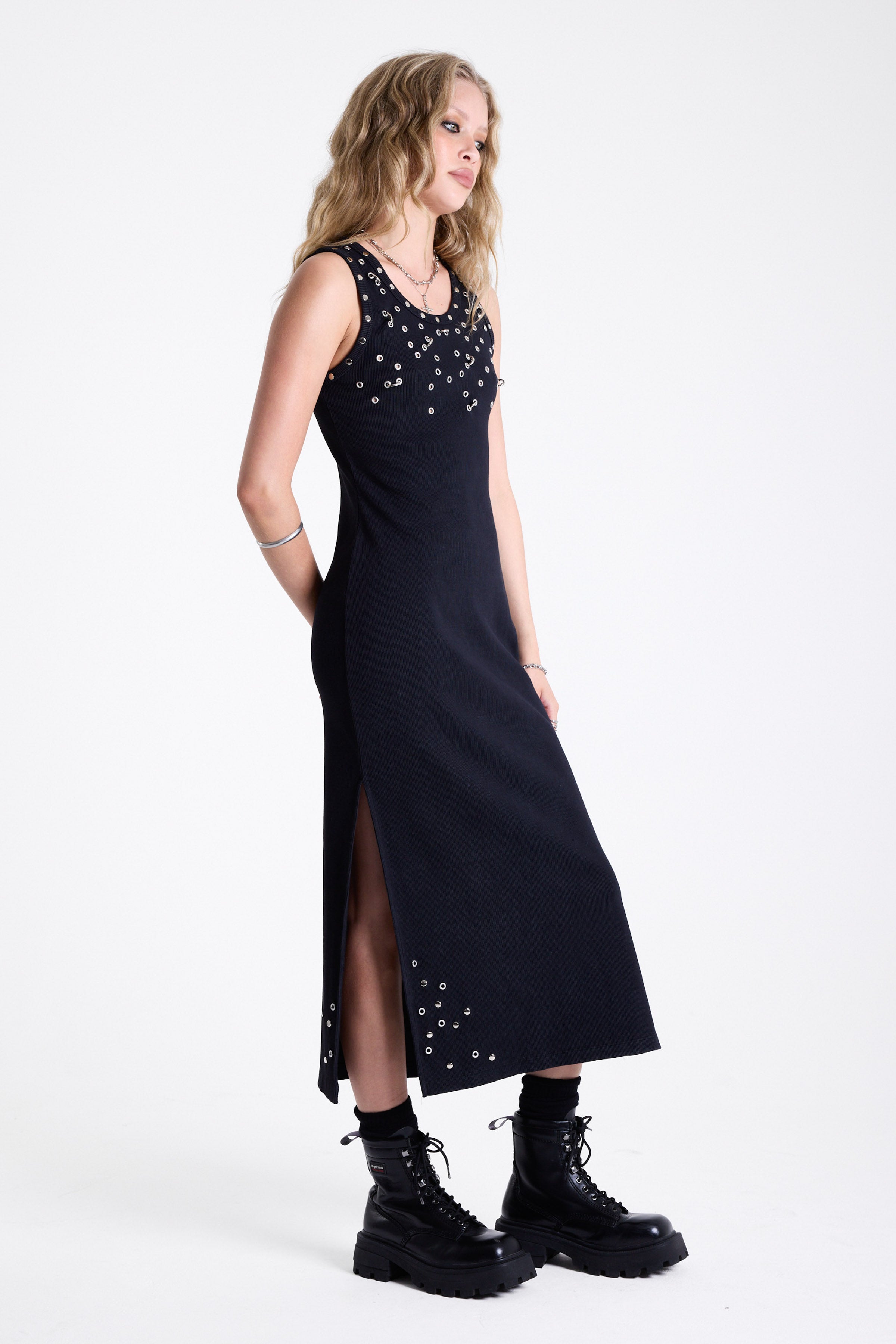 Black bodycon maxi dress with silver stud and piercing detail, worn by model