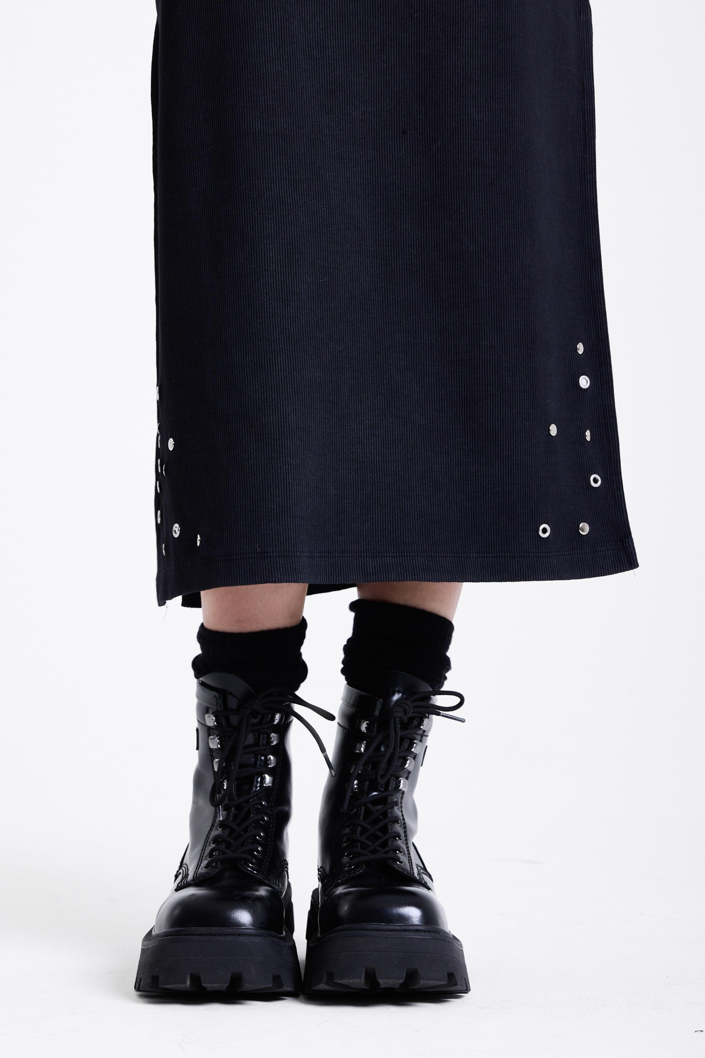 Black bodycon maxi dress with silver stud and piercing detail, worn by model