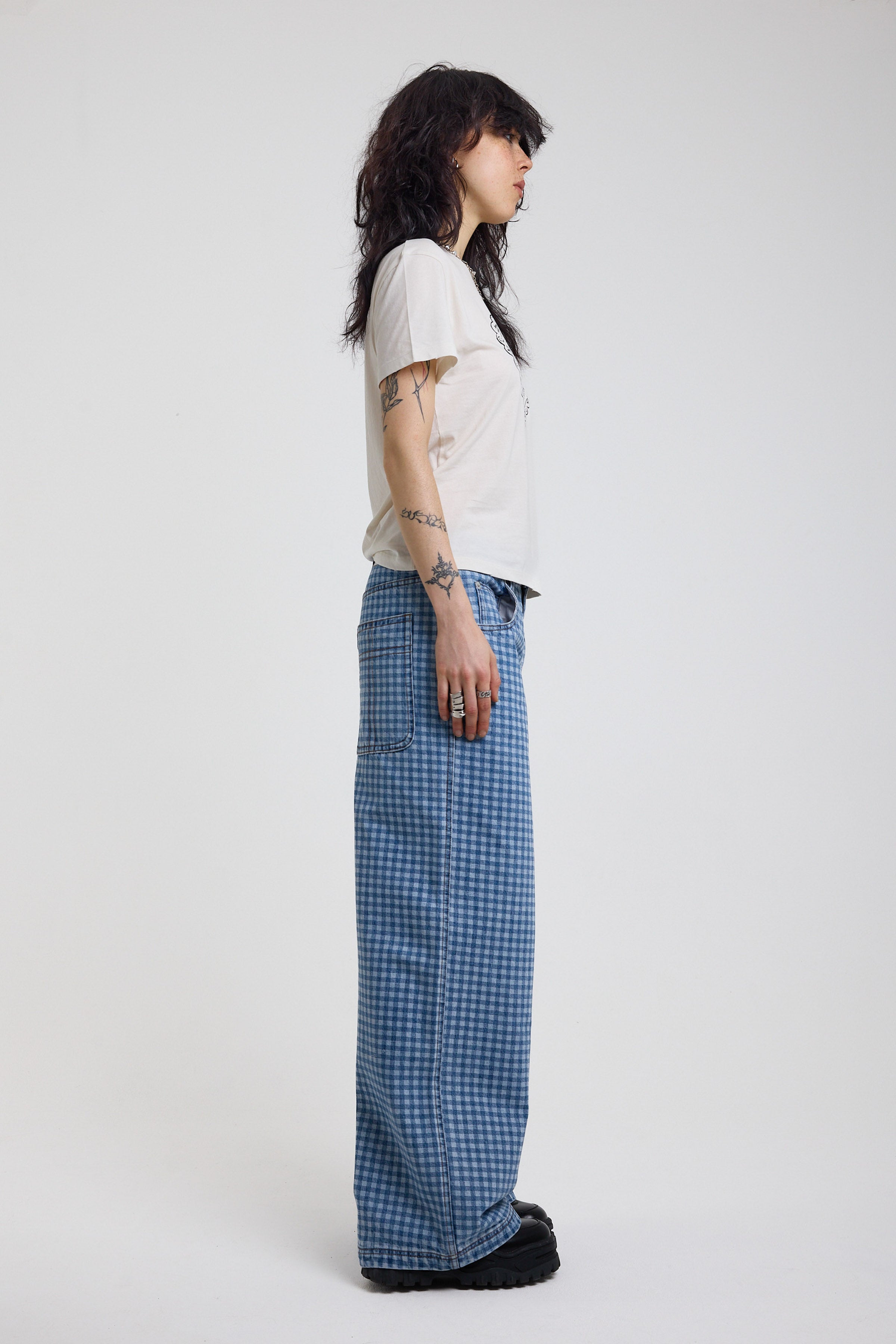 Side view of blue gingham checked baggy wide leg release jeans, worn by model