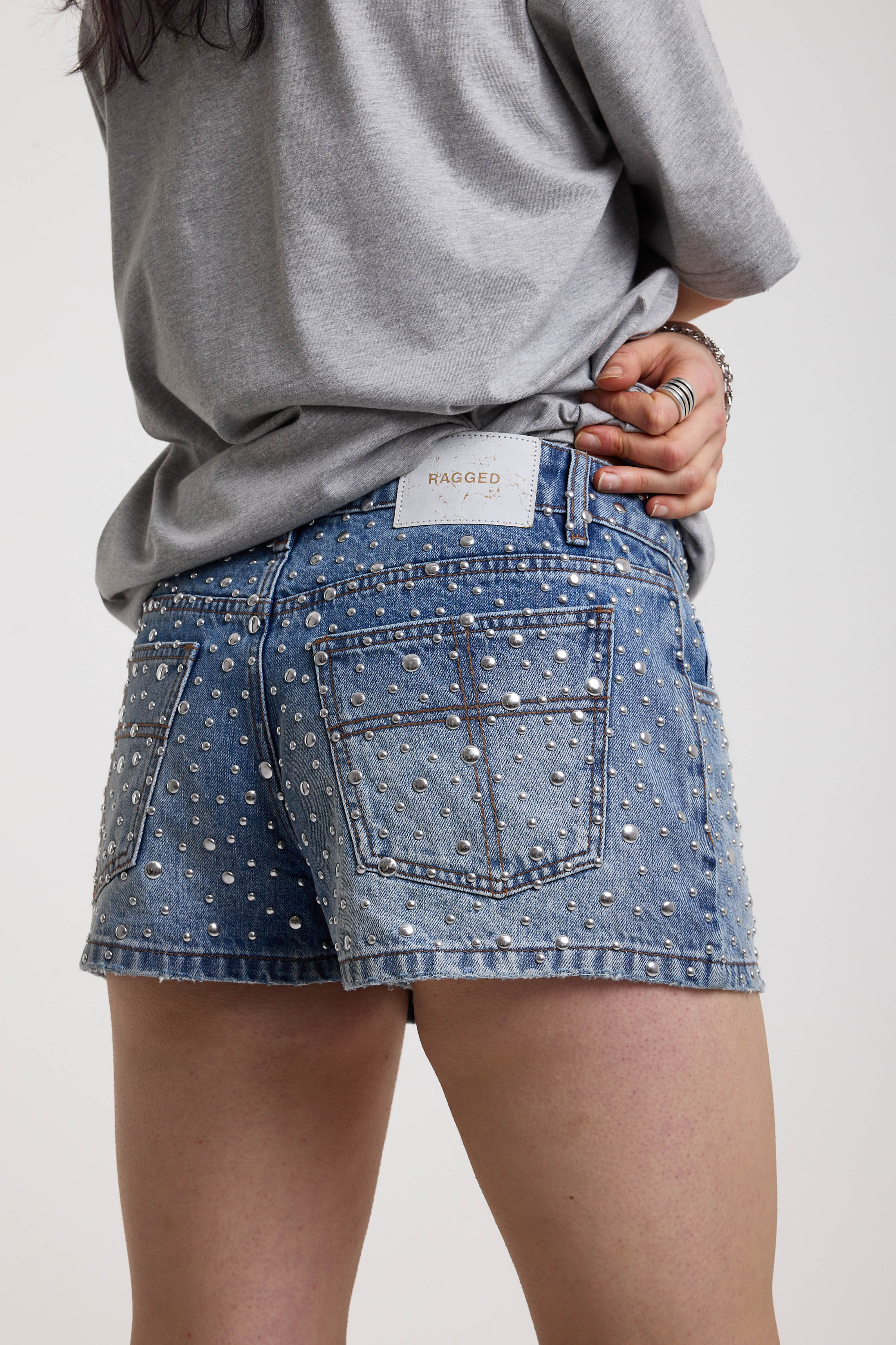 Light wash denim hotpants with all over hot fix silver studs, worn by model