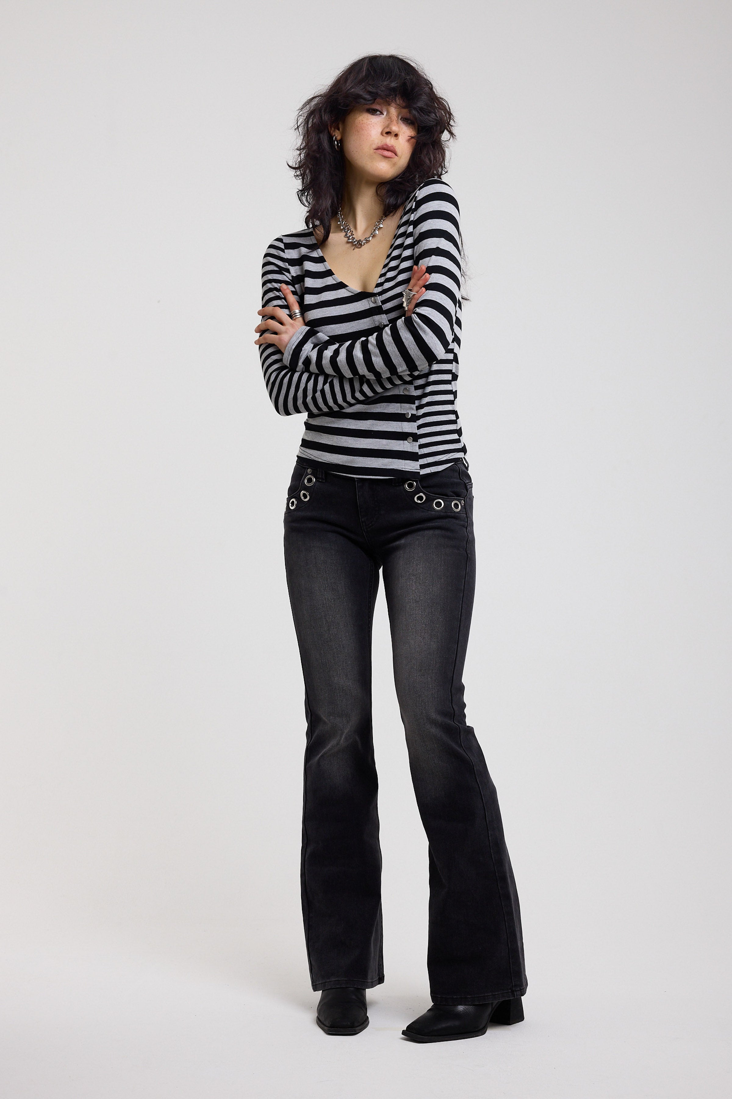 Washed black flare bootcut jeans with eyelet cut out detail, worn by model