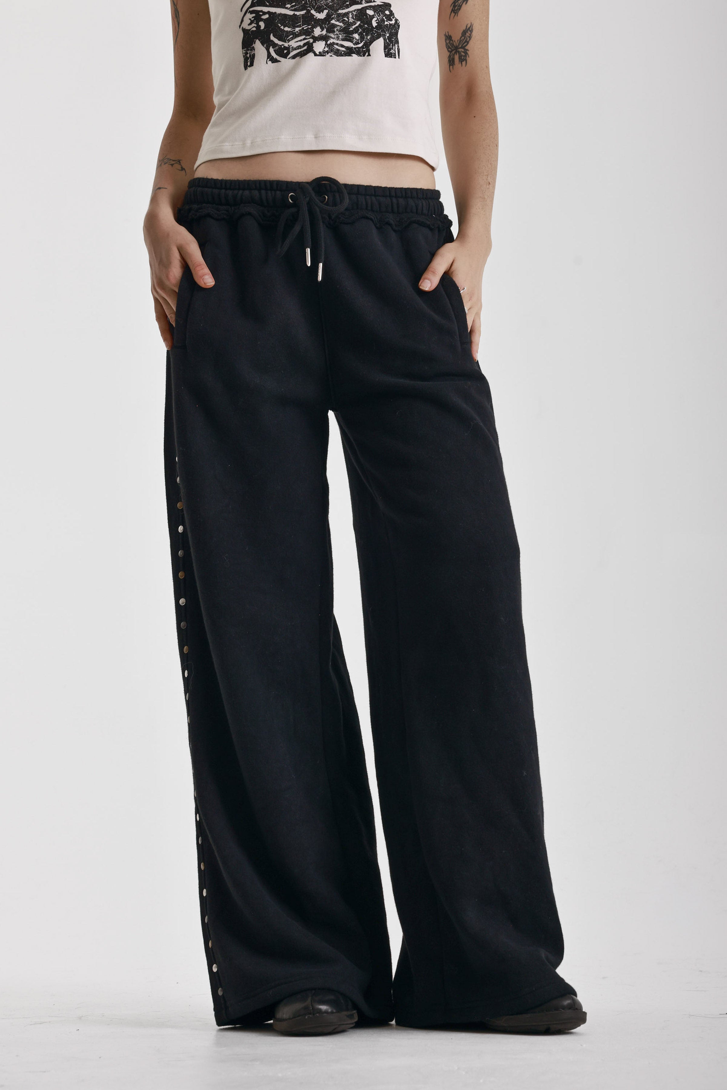 Washed black wide leg sweatpants with mixed metal studs, worn by model