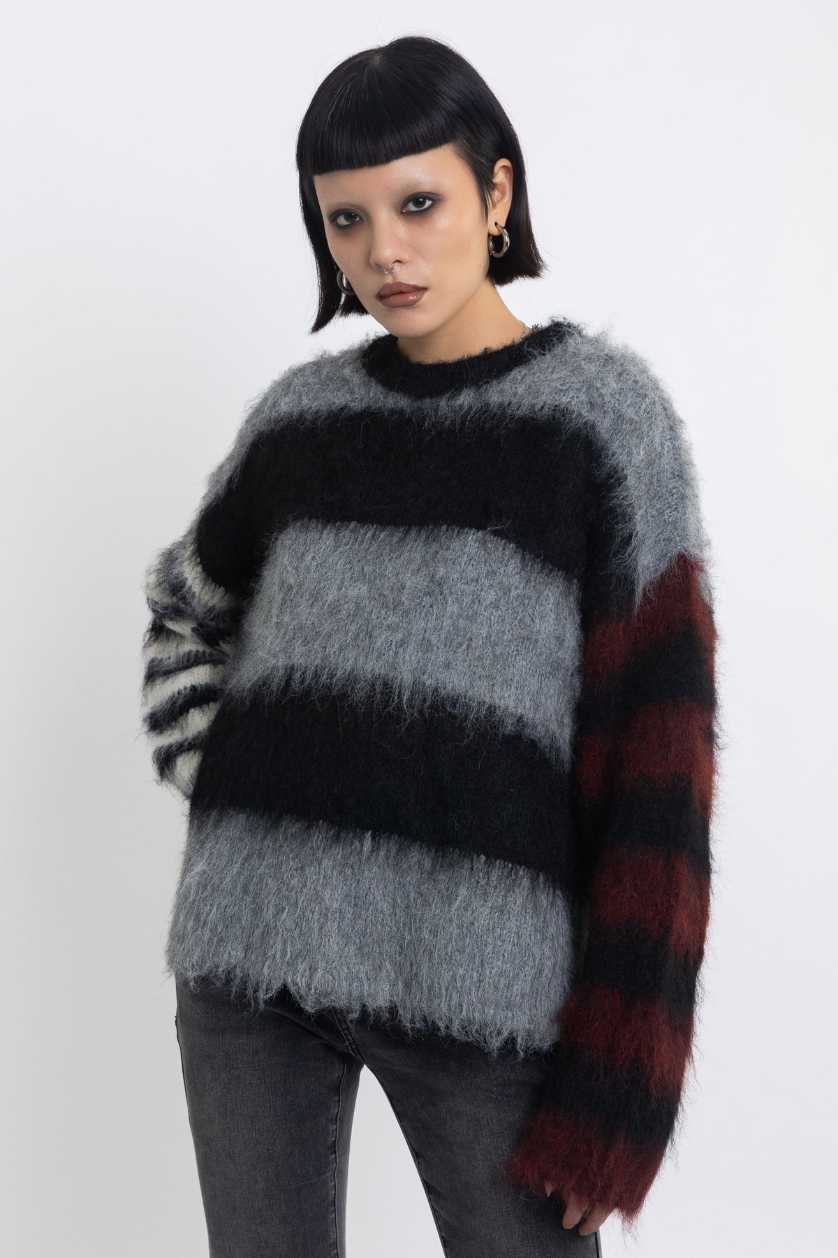 Black and grey colourblock stripe fuzzy knit jumper with contrasting stripe sleeves, worn by model