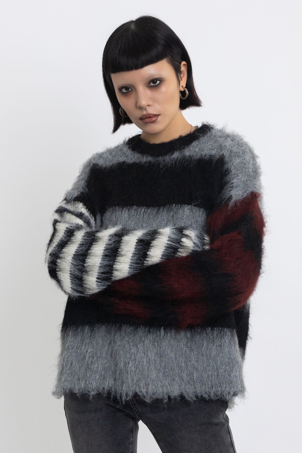 Black and grey colourblock stripe fuzzy knit jumper with contrasting stripe sleeves, worn by model