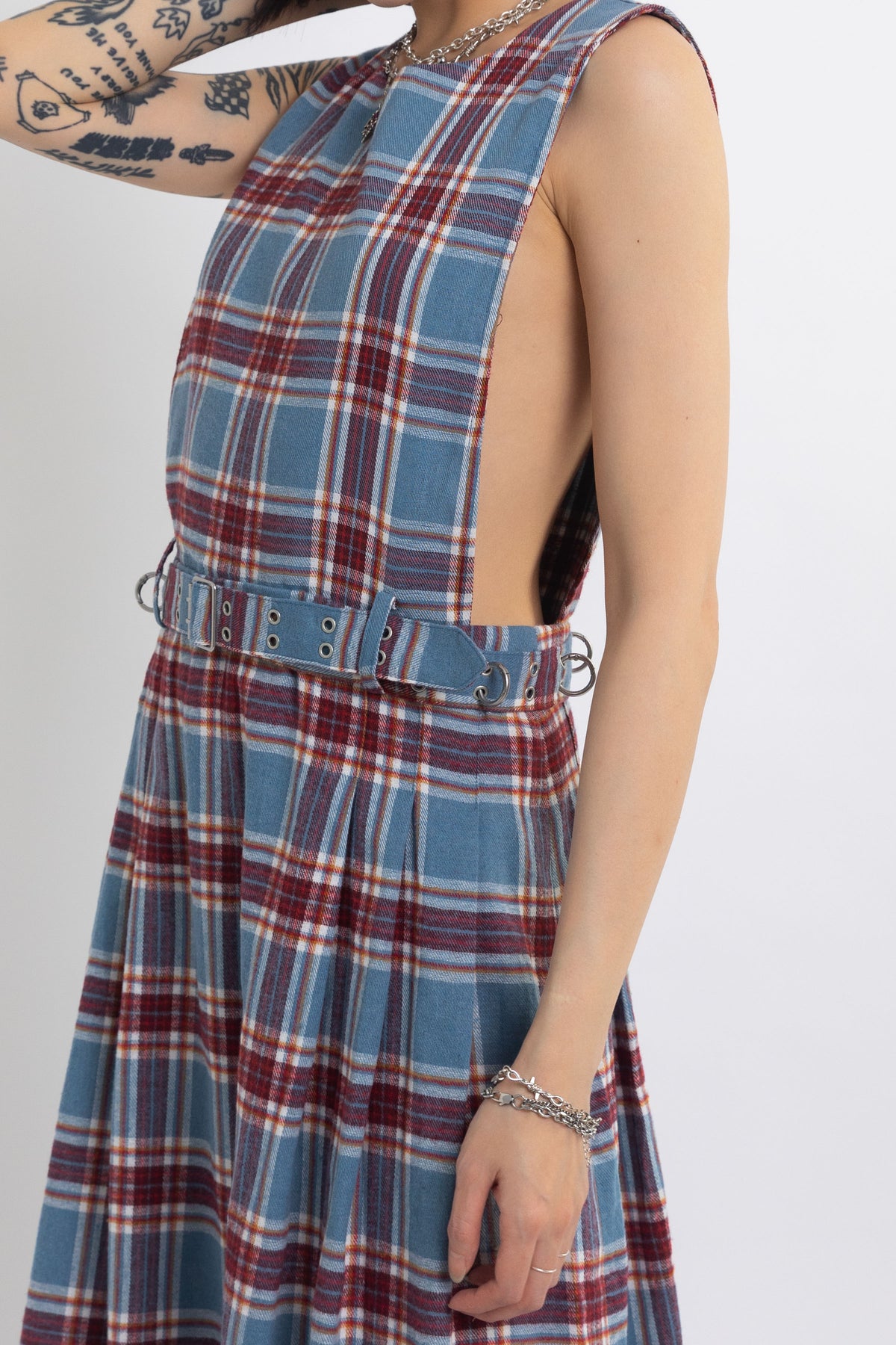 Sleeveless blue plaid check pinafore midi dress with eyelet hardware belt, worn by model