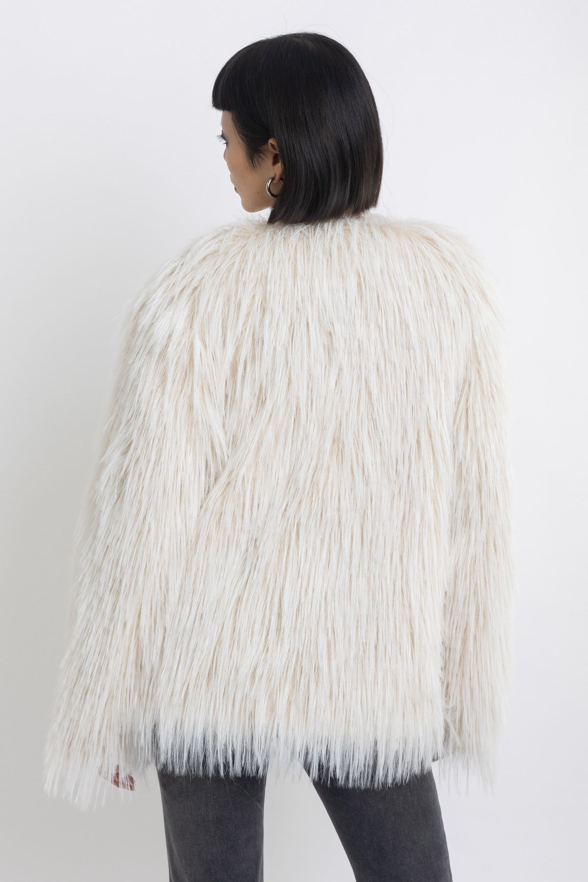 Ecru shaggy faux fur jacket with faux leather eyelet detail straps, worn by model