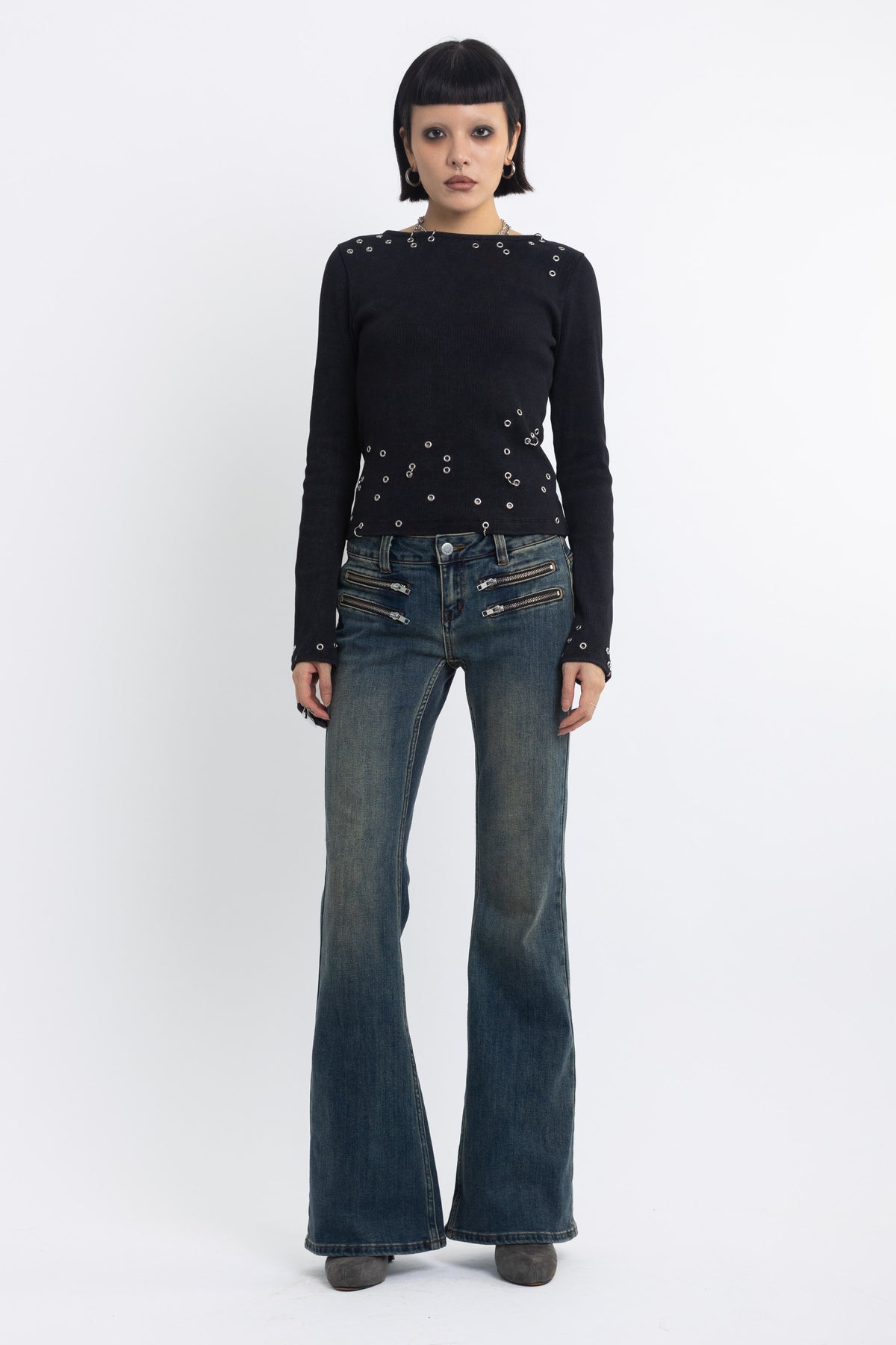 Dirty blue wash low rise flare jeans with double zip hip detail, worn by model