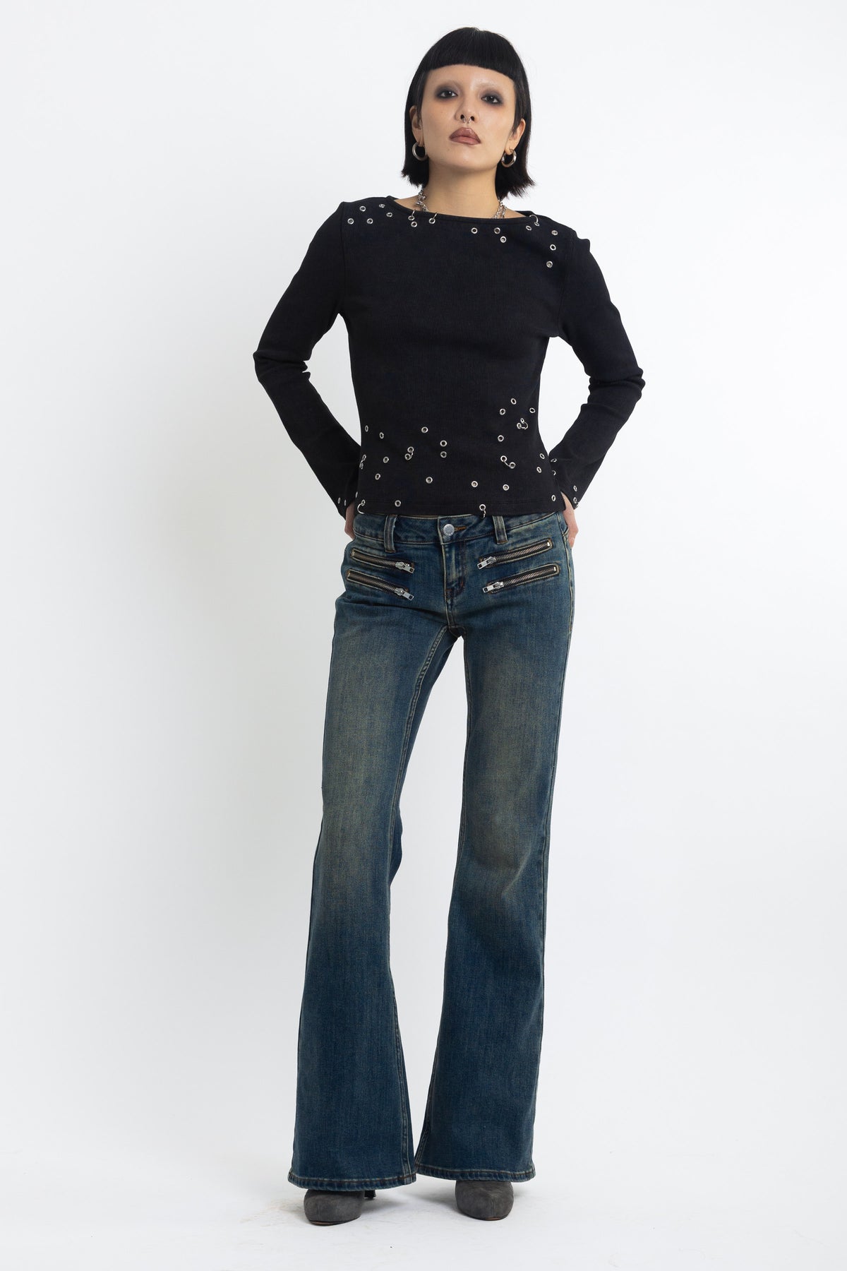 Dirty blue wash low rise flare jeans with double zip hip detail, worn by model