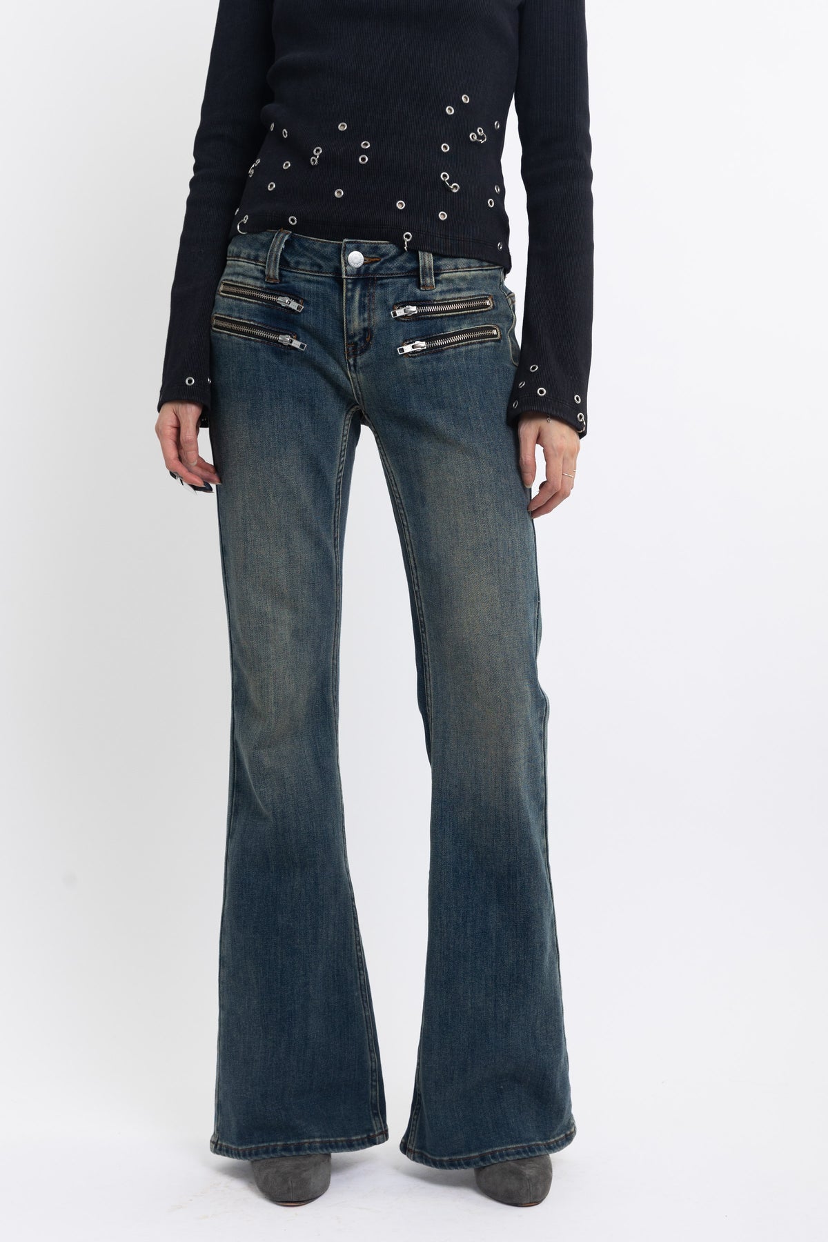 Dirty blue wash low rise flare jeans with double zip hip detail, worn by model