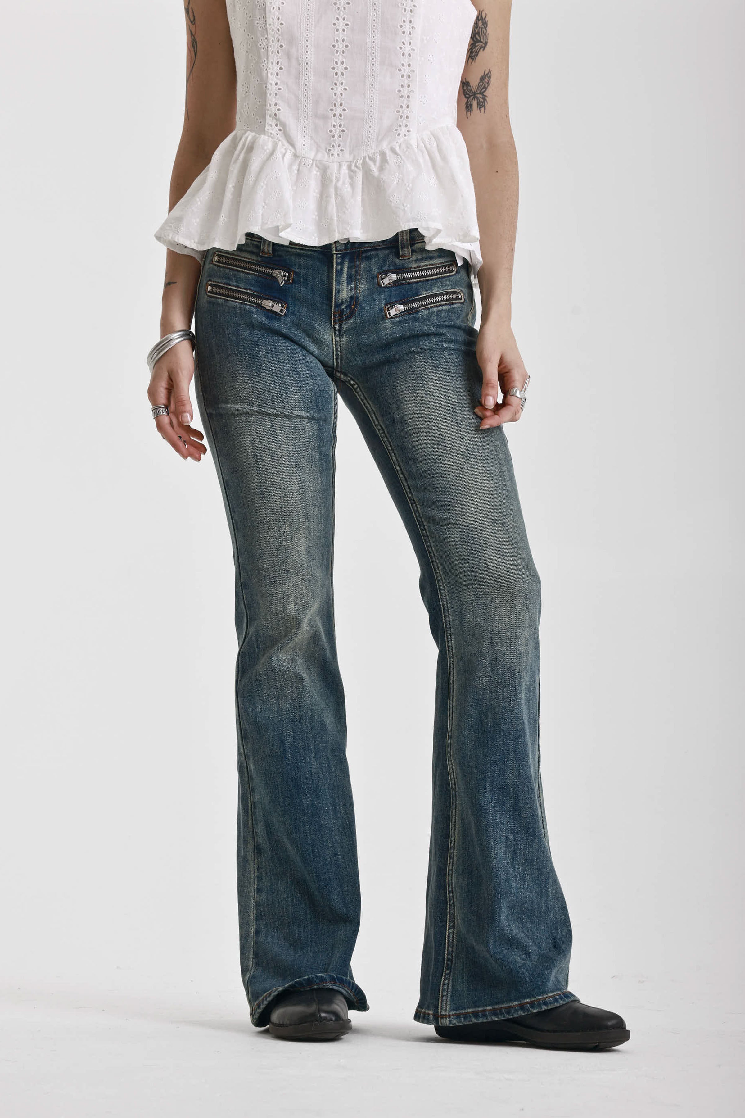 Dirty blue wash flare jeans with zip detail, worn by model