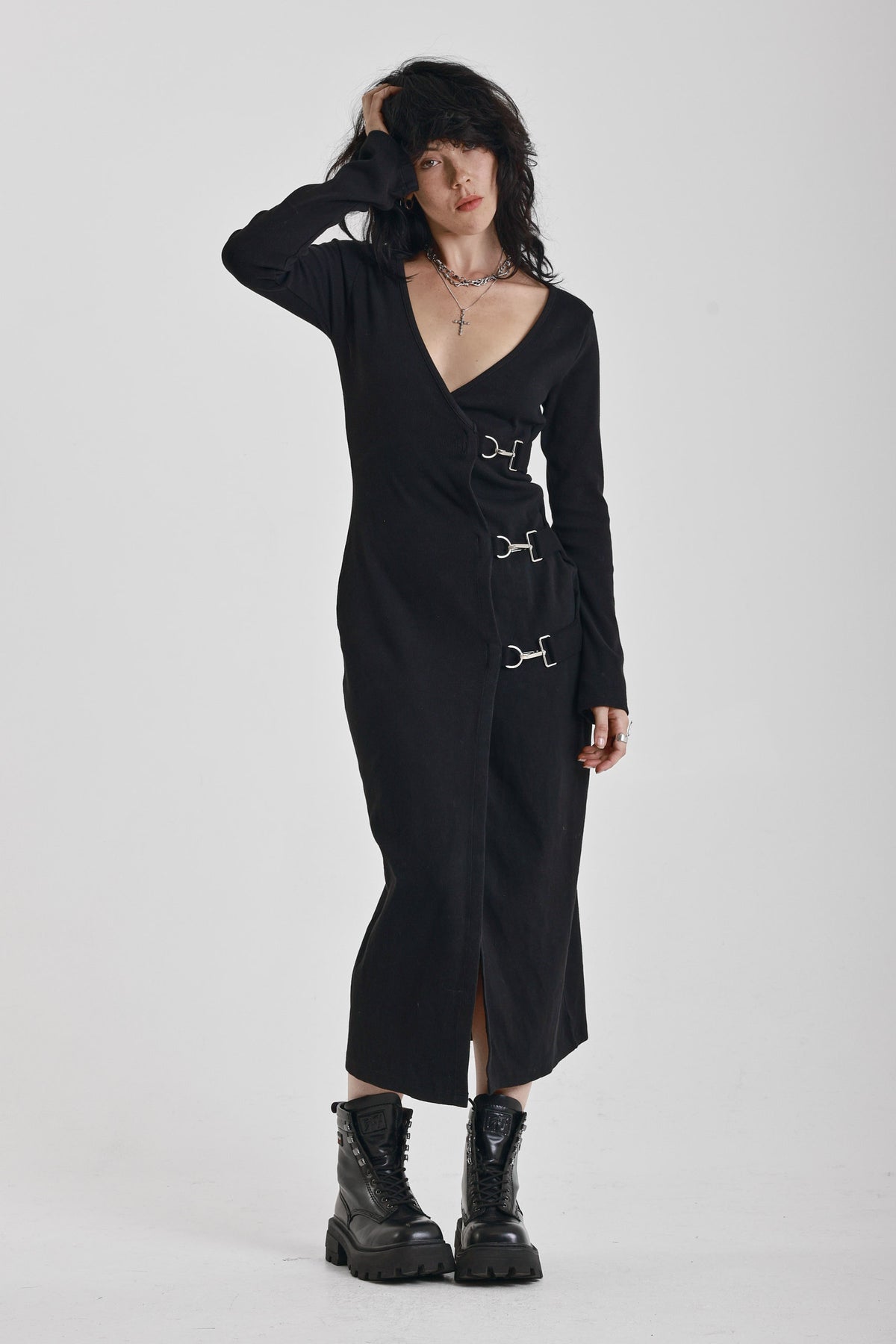 Black wrap front midi dress with silver trigger clasps and long sleeves, worn by model