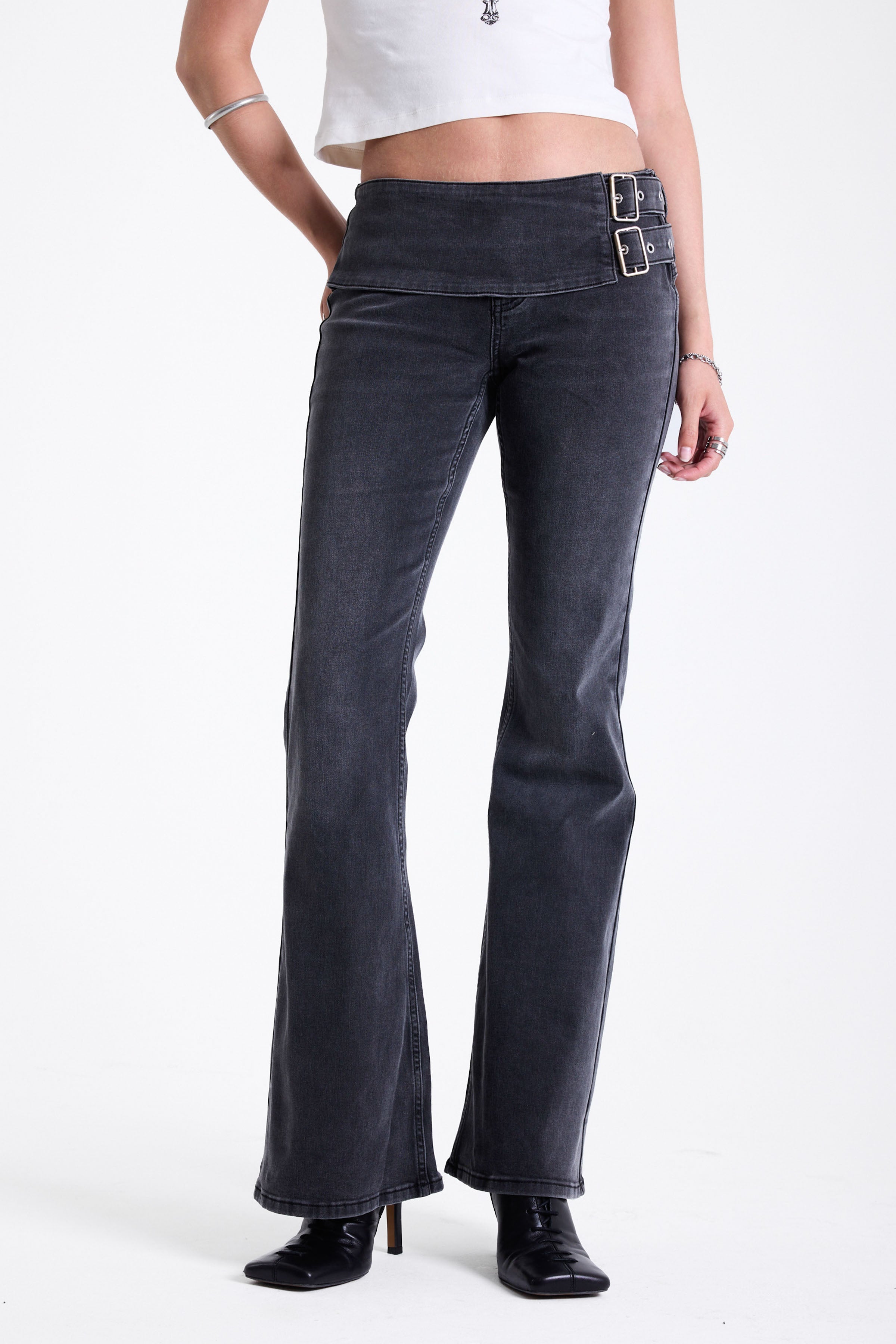 Washed black flare bootcut jeans with double buckle belt detail, worn by model