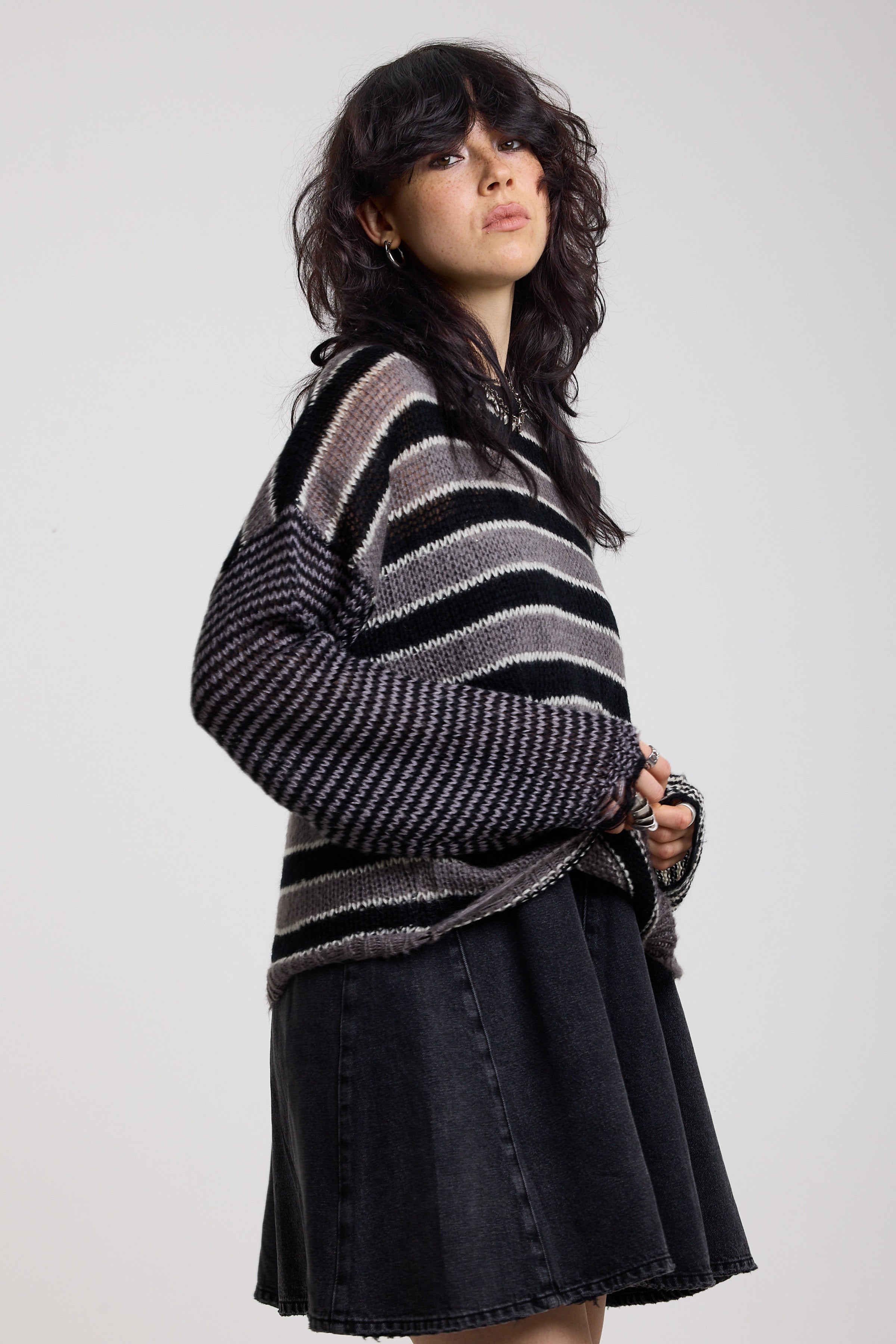 Black and white stripe oversized knit jumper with grunge distressed details, worn by model