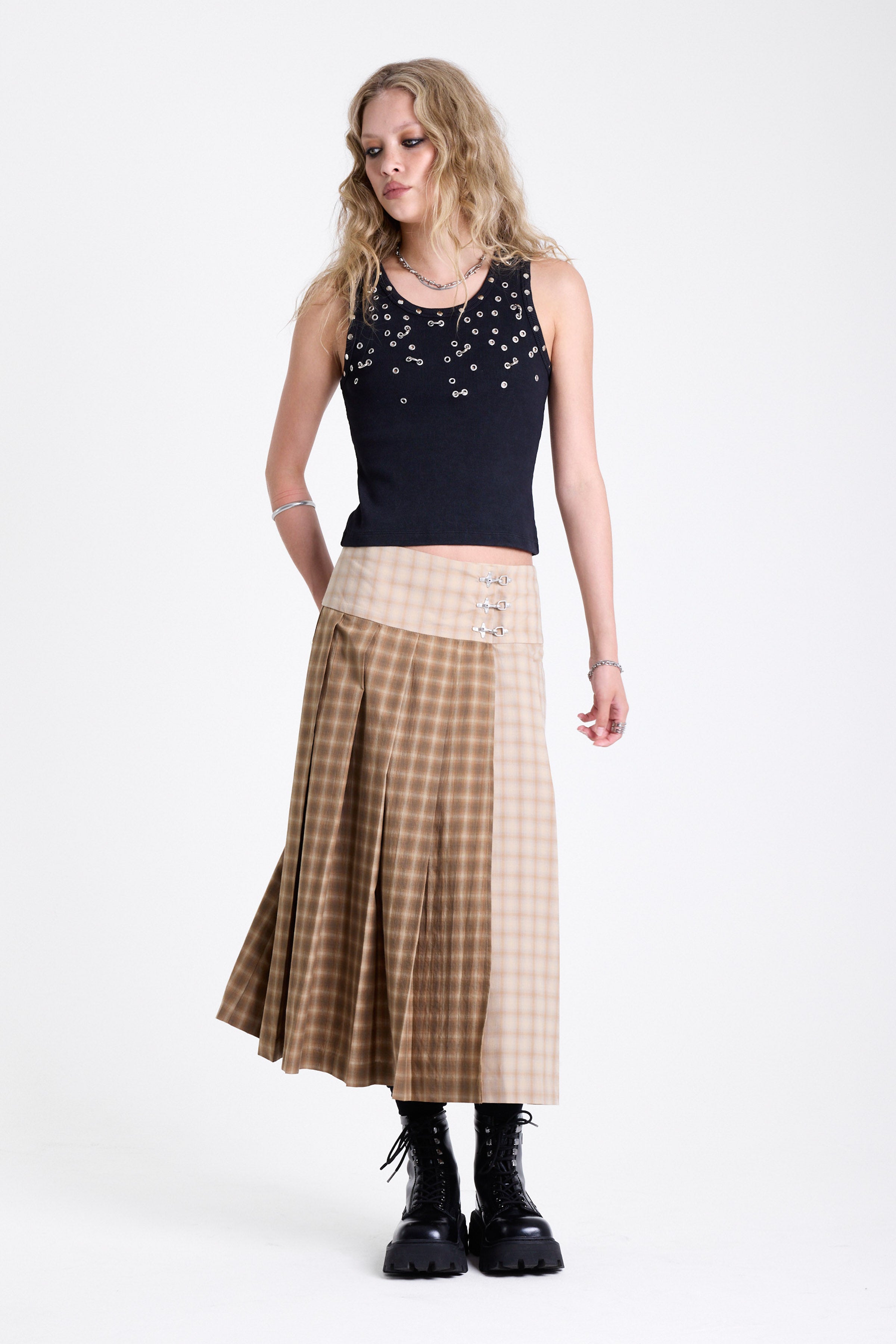 Beige and brown plaid pleated kilt maxi skirt with silver clasp detail and a wide waistband, worn by model