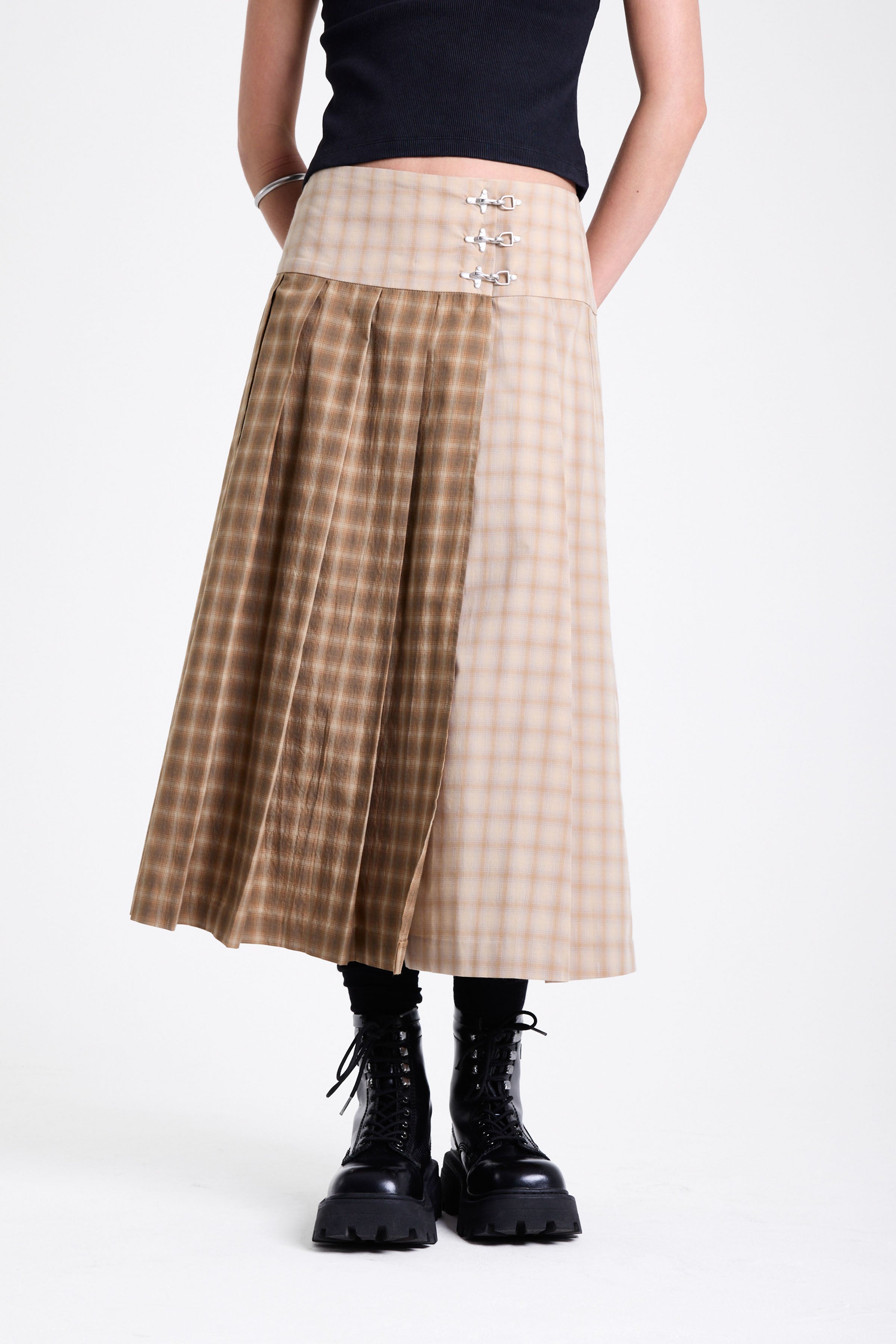 Beige and brown plaid pleated kilt maxi skirt with silver clasp detail and a wide waistband, worn by model