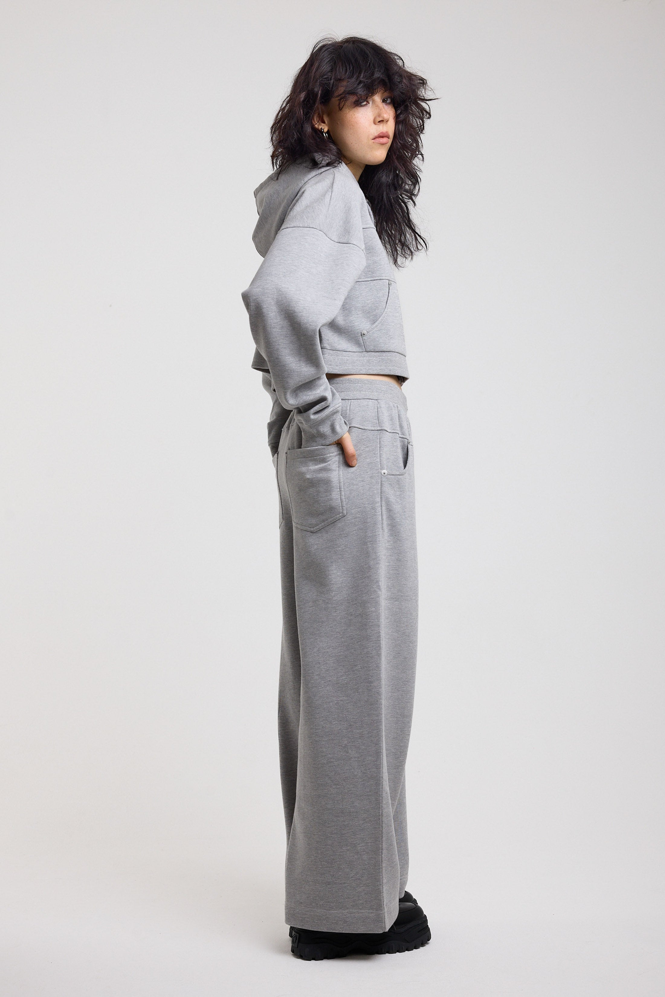 Grey wide leg trackpants with silver hardware clasp detail, worn by model
