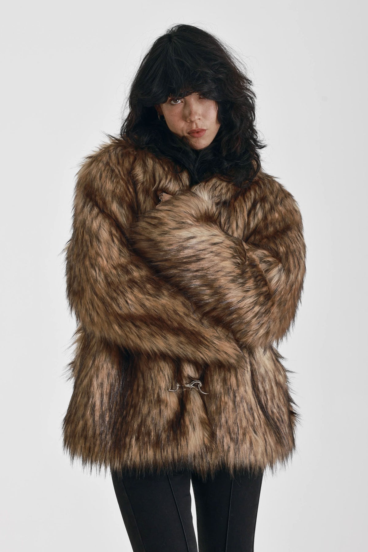 Oversized brown faux fur jacket with oversized collar and silver buckle clasps, worn by model
