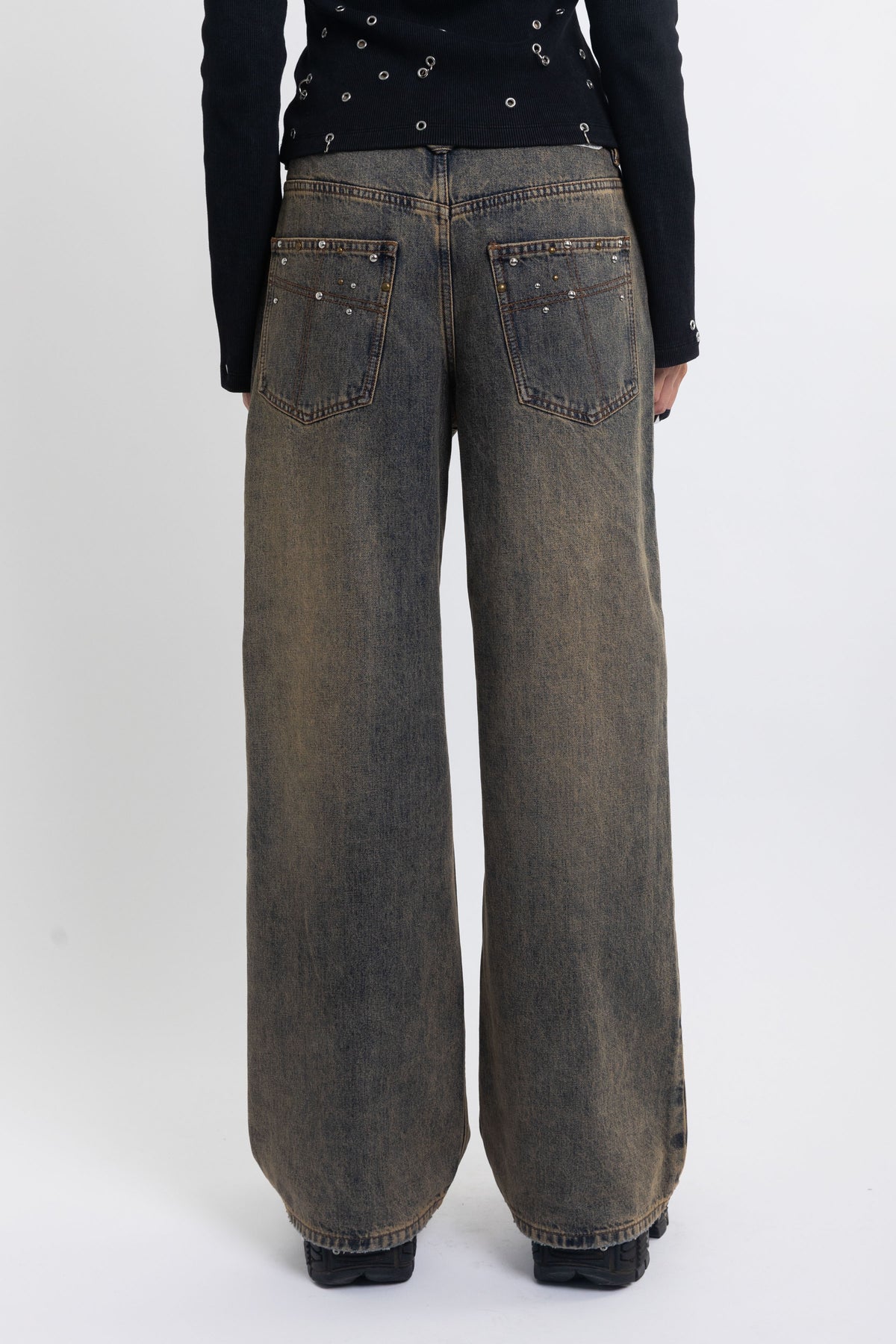 Dirty wash ultra baggy colossus jeans with scattered studs, worn by model
