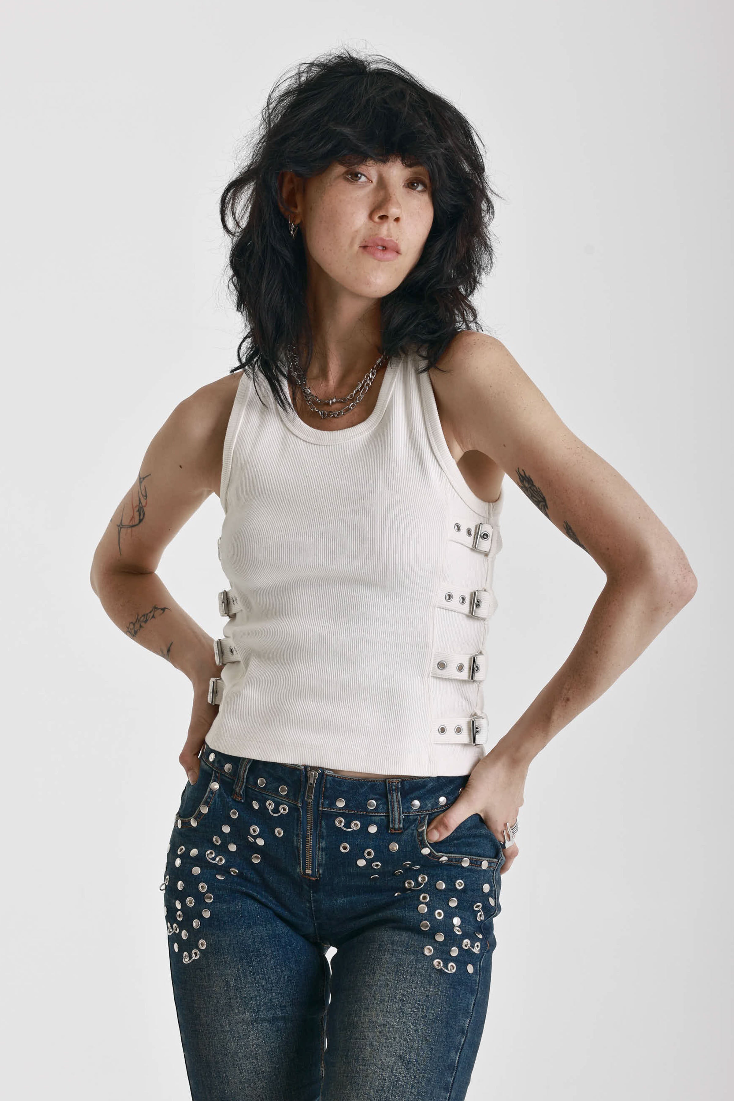 Ecru ribbed tank top with eyelet and buckle strap detail, worn by model