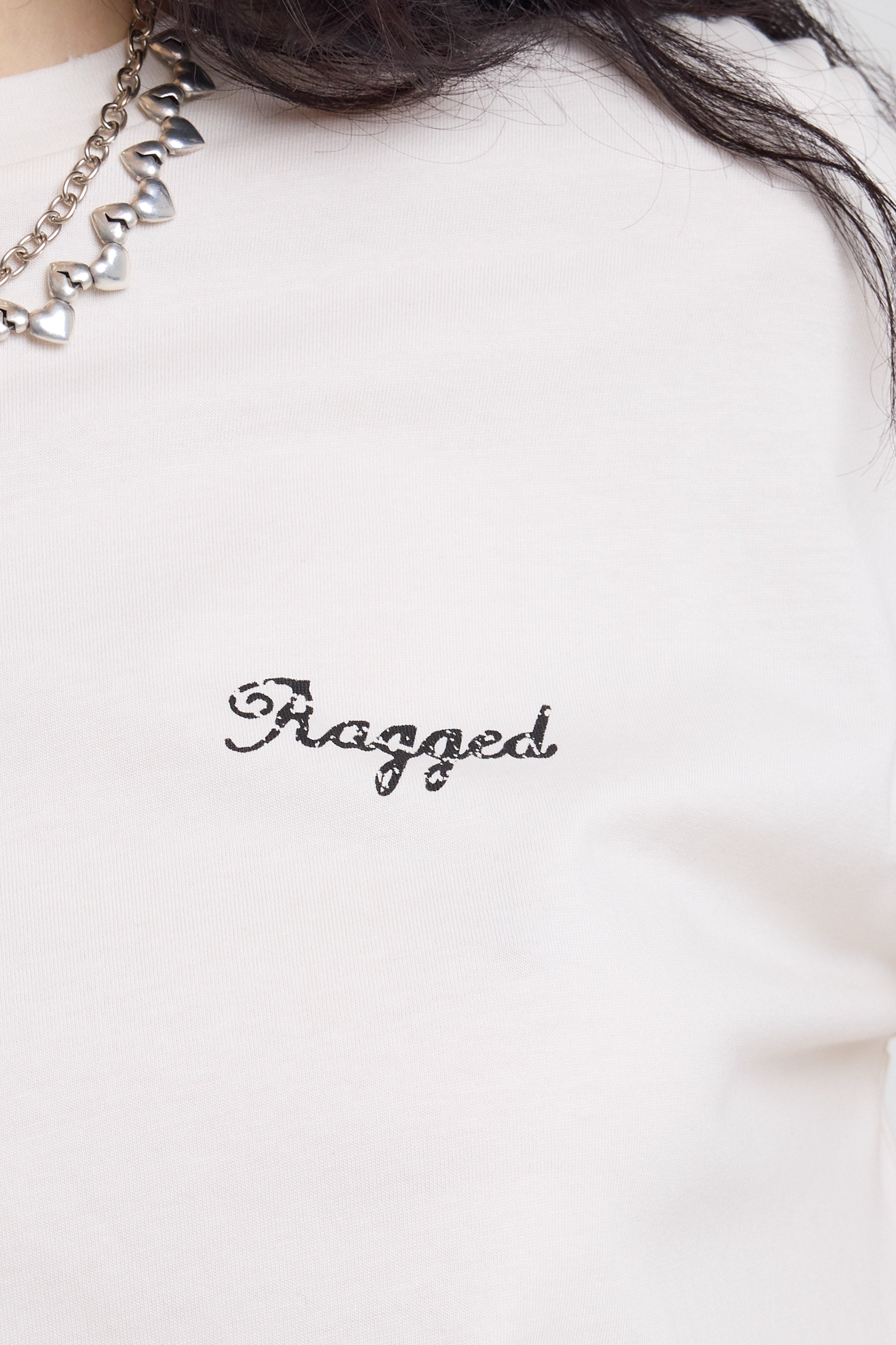 Close up of Ragged vintage logo on ecru oversized t-shirt worn by model