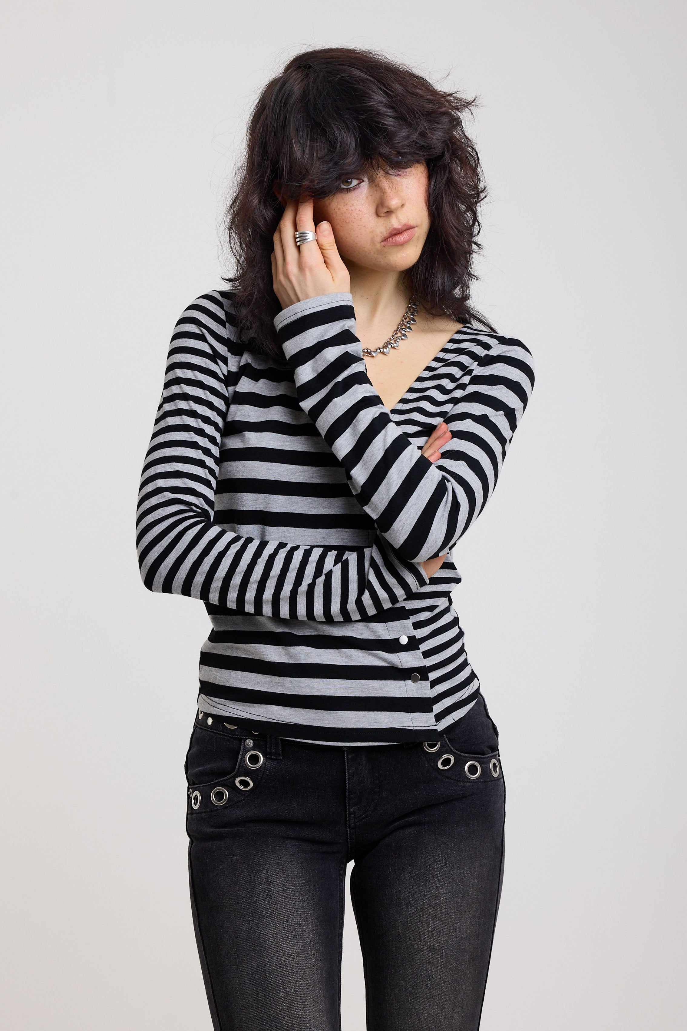 Grey and black stripe asymmetric long sleeve top with stud fastening, worn by a model