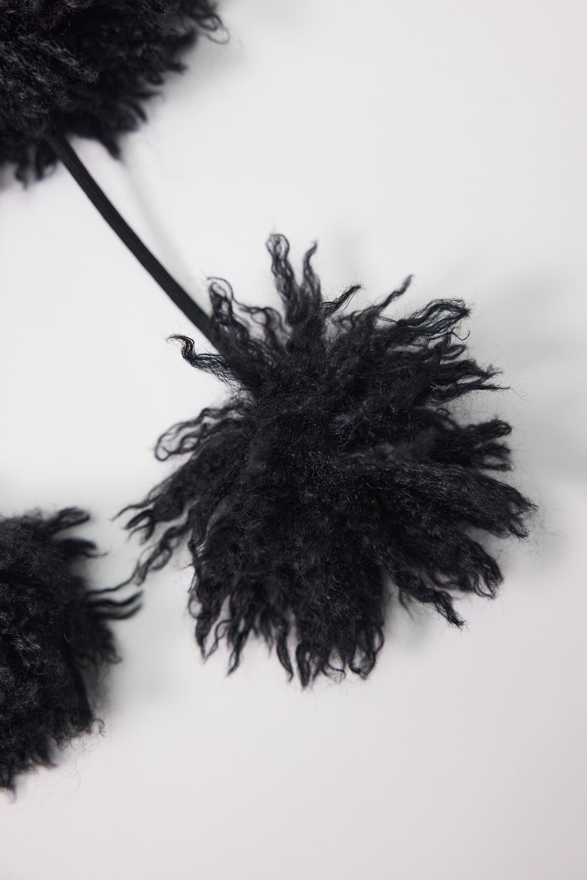 Black shaggy faux fur trapper hat with pom poms