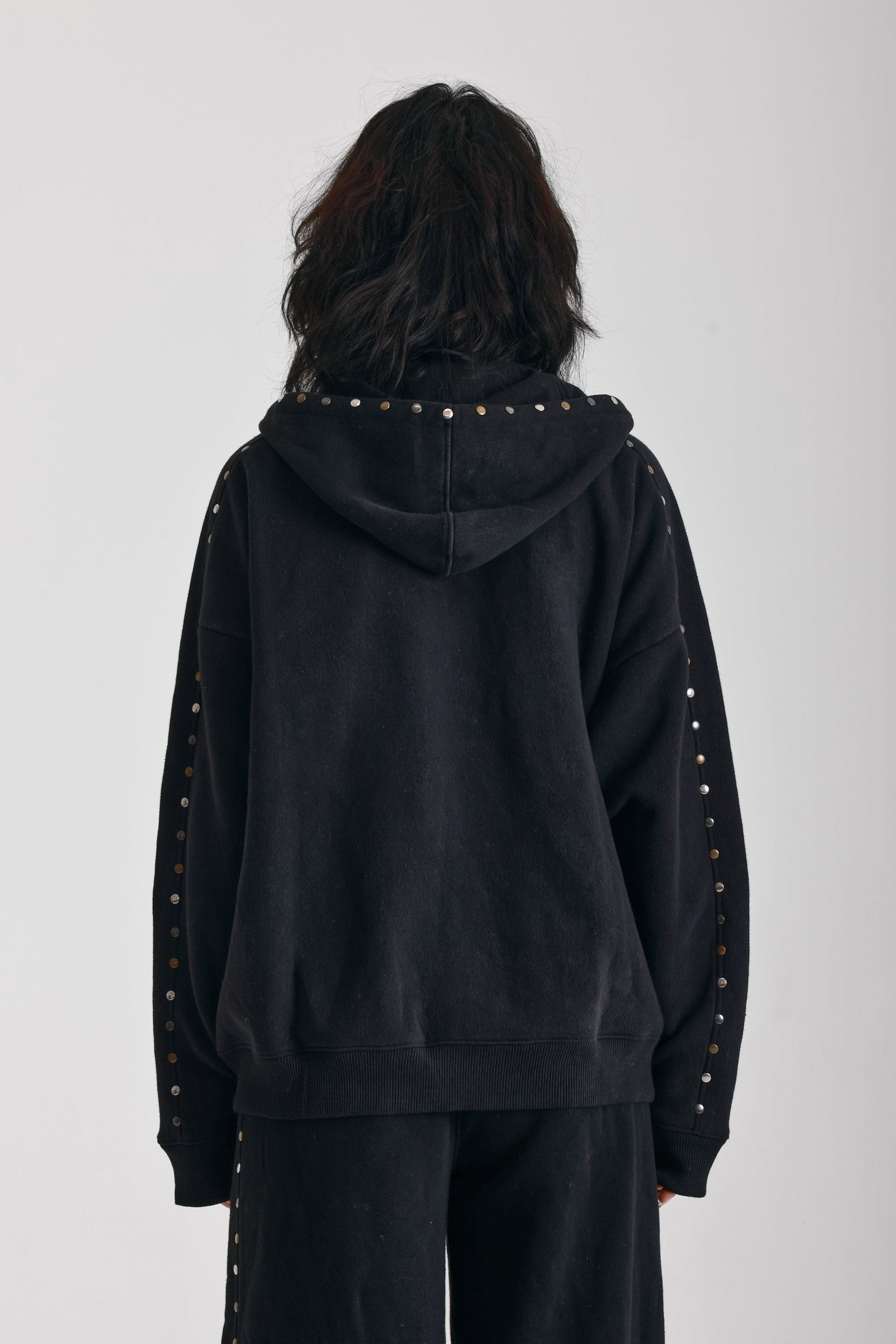 Washed black oversized zip up hoodie with mixed metal stud detail, worn by model
