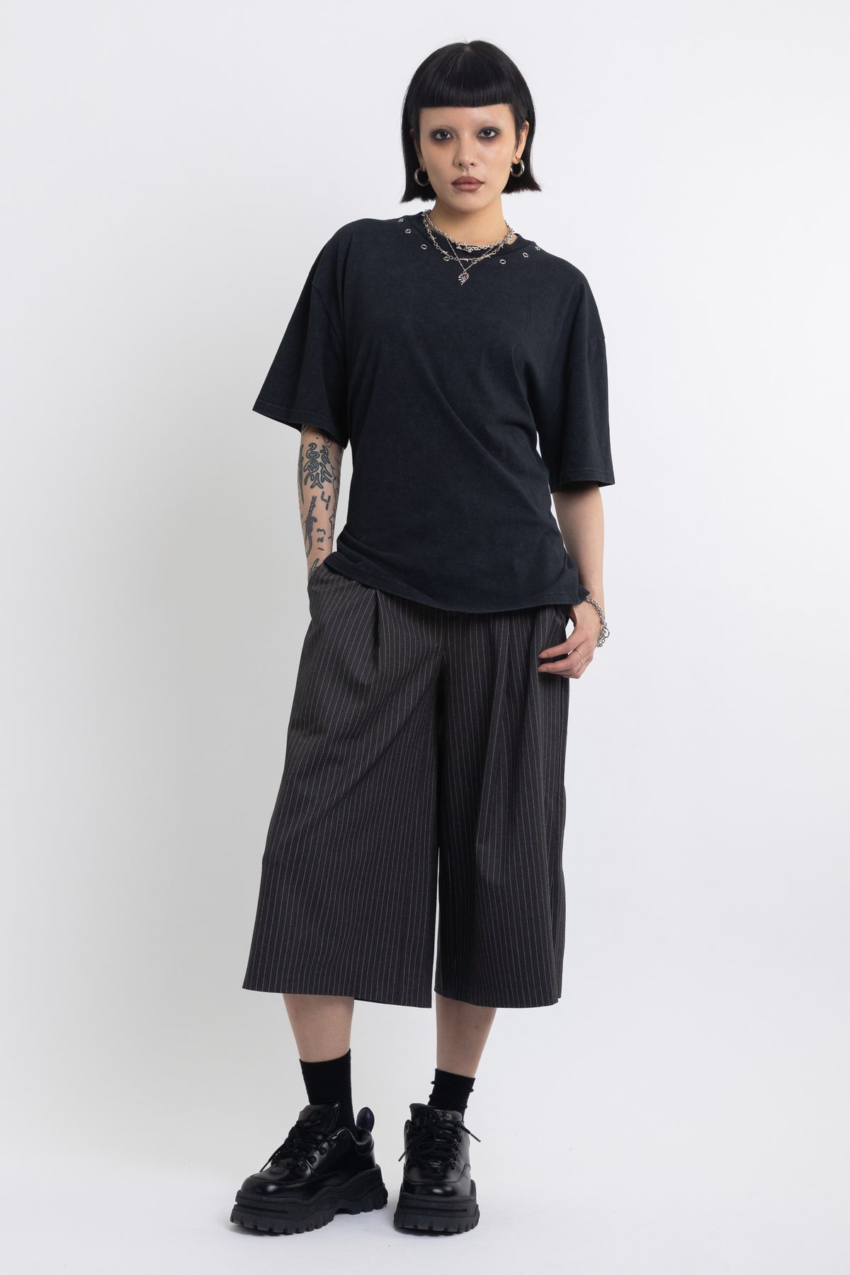 Black oversized t-shirt with open back and eyelet studs, worn by model