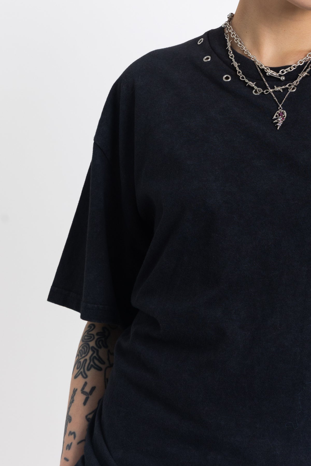 Black oversized t-shirt with open back and eyelet studs, worn by model