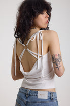 White strappy cami top with tie straps, cowl back and silver O rings, worn by model