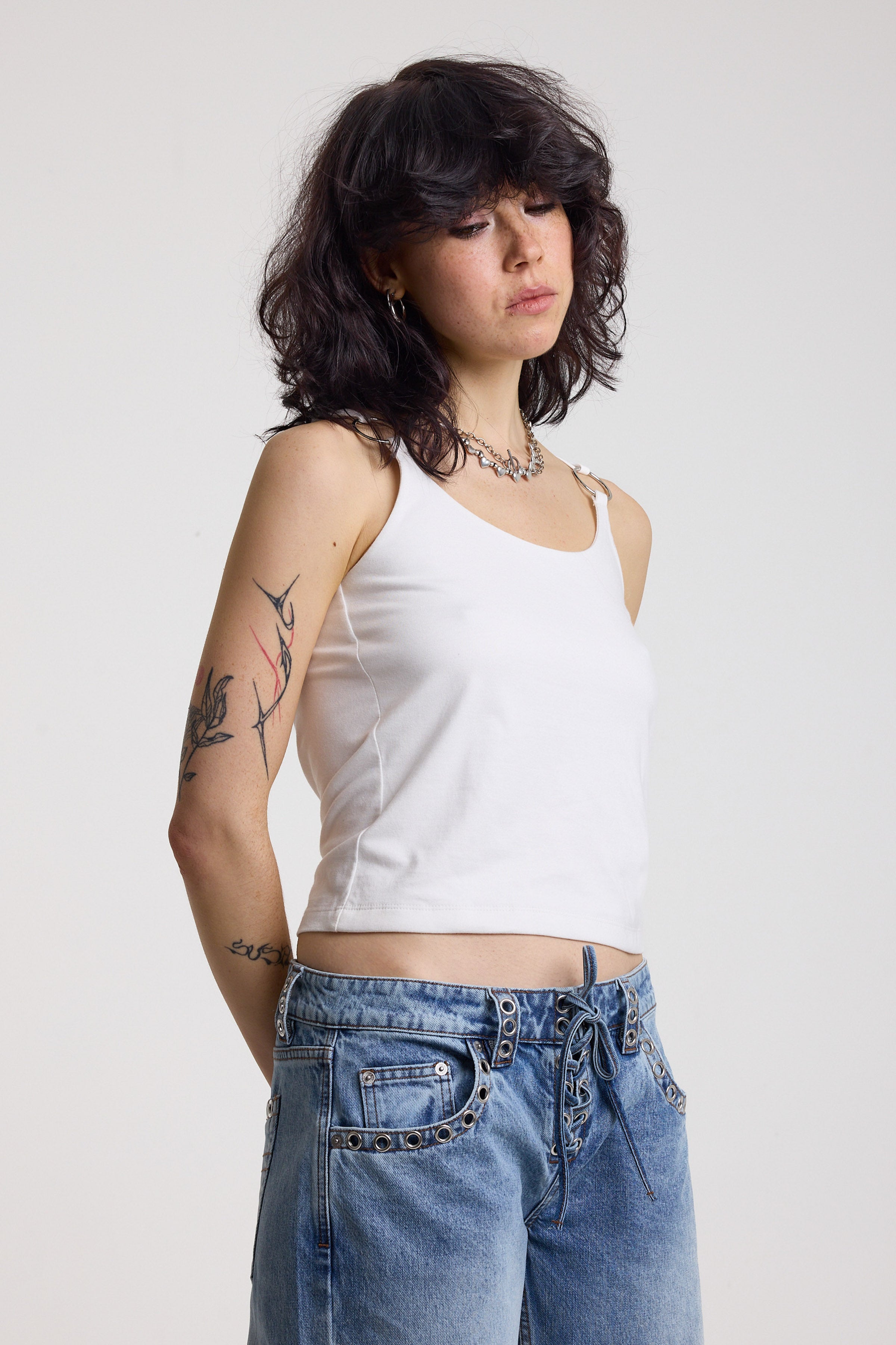 White strappy cami top with tie straps, cowl back and silver O rings, worn by model