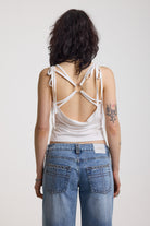 White strappy cami top with tie straps, cowl back and silver O rings, worn by model