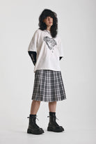 Black and white mixed check midi skirt with silver piercing hardware, worn by model