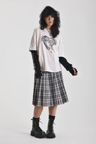 Black and white mixed check midi skirt with silver piercing hardware, worn by model