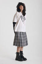 Black and white mixed check midi skirt with silver piercing hardware, worn by model